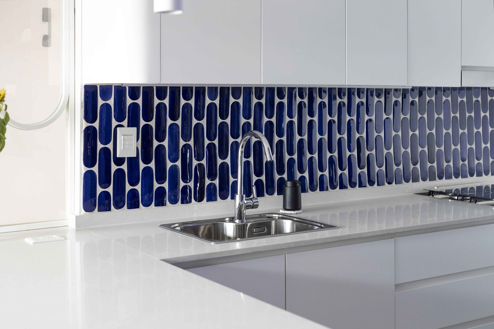 Cocina moderna con azulejos azules y mesada blanca — proyecto Julián Alvarez, por Bouré Studio, en Palermo