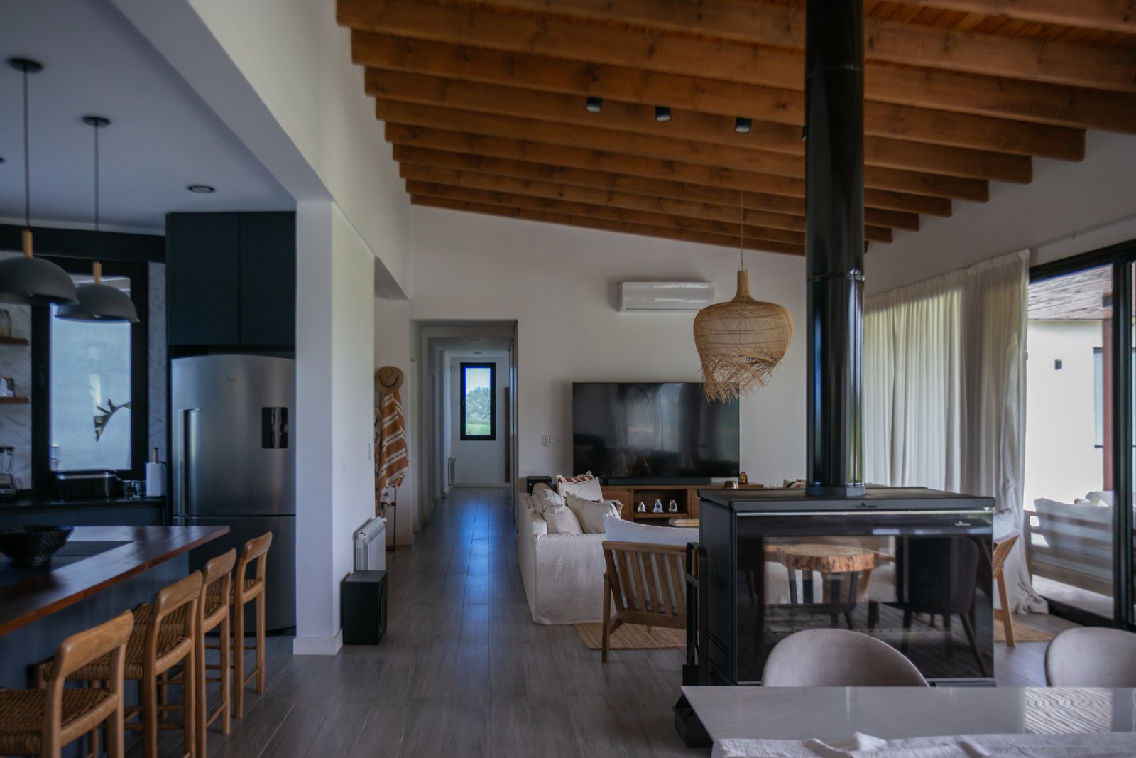 Living comedor rústico moderno con vigas de madera y chimenea — proyecto CASA AB, por SEDE Arq., en Av. Pereda S/N