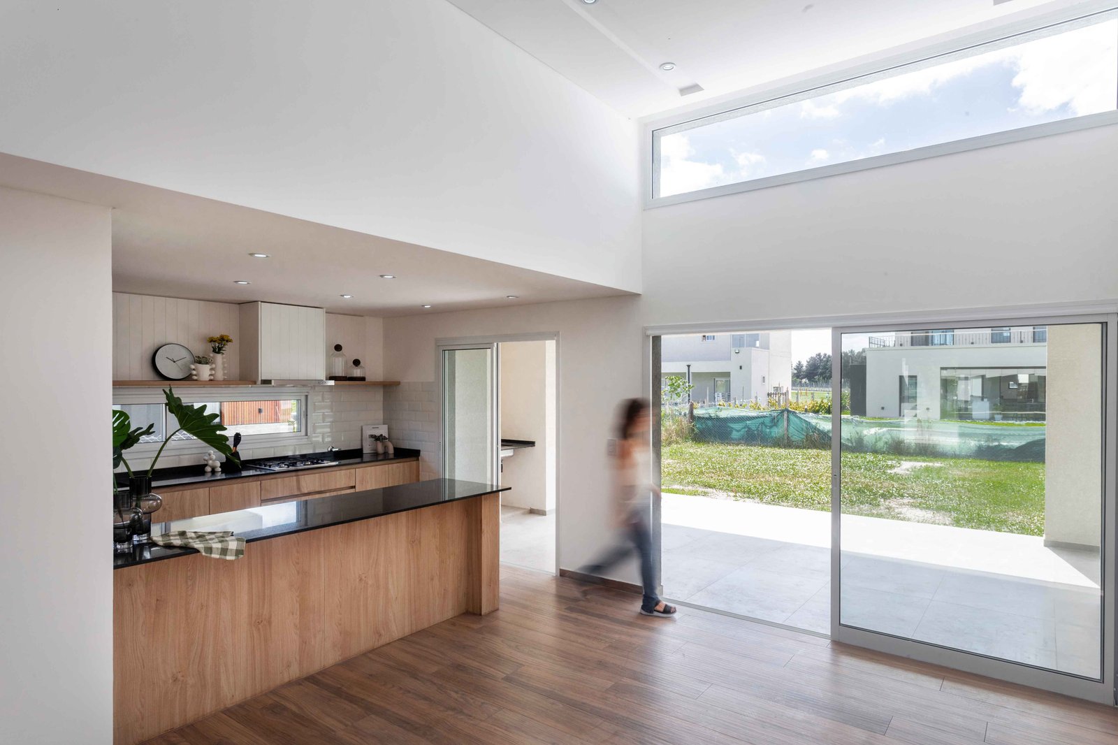 Cocina moderna de doble altura con isla y ventanales amplios — proyecto San Felipe, por Estudio Stepa, en Canning