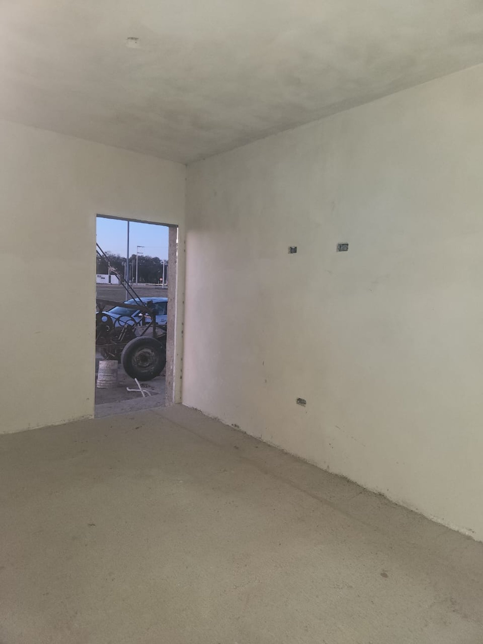 Espacio interior sin terminar con paredes blancas y piso de cemento — proyecto PROYECTO DN, por Todo con A, en X5125 Monte Cristo
