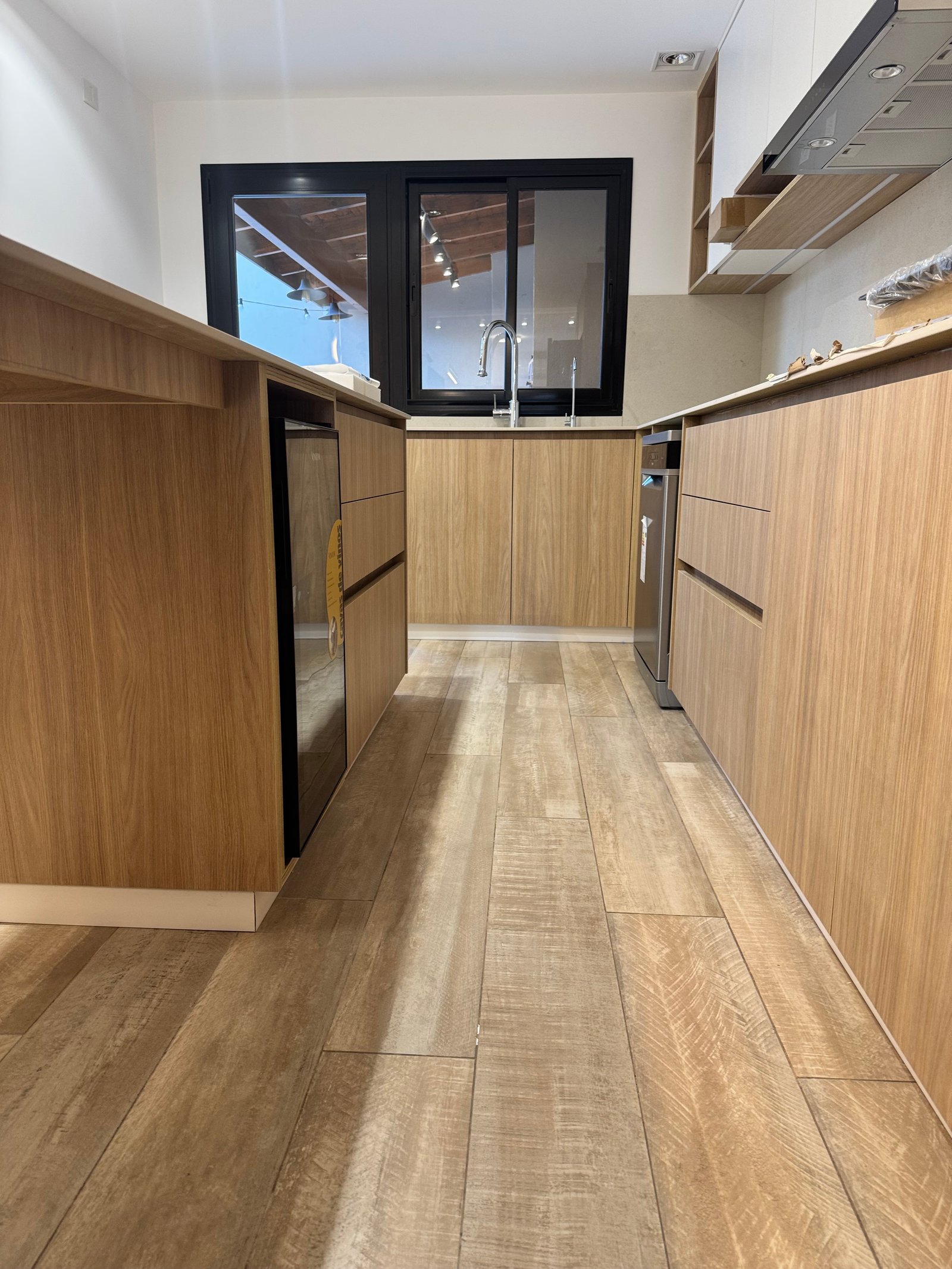 Cocina moderna minimalista con muebles de madera natural y luz indirecta — proyecto CASA LEAN, por Estudio Grupo 32, en Vicente López