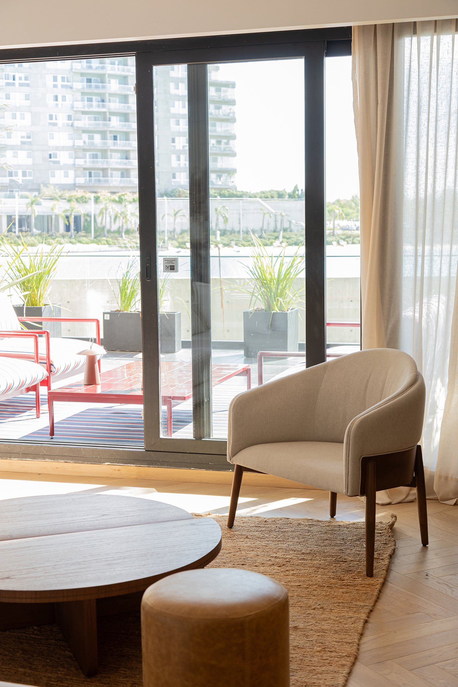 Living moderno con terraza y sillón curvo — proyecto Pia Magri, por Gaby Alfonso, en B1648 Tigre