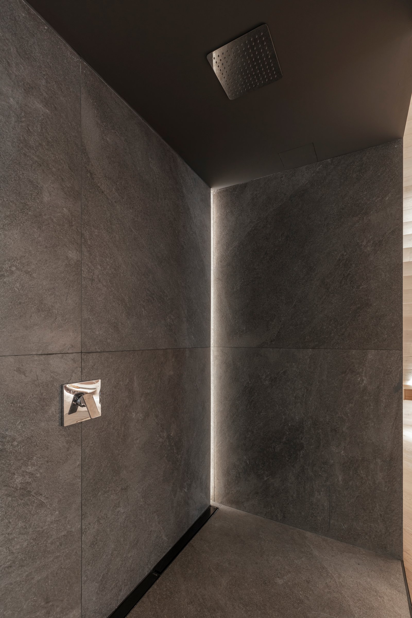 Baño moderno con paredes de piedra gris, ducha empotrada y grifería cromada — proyecto Casa Foa 2024 | Ritual de bienestar | Wellness ritual | Lucia Quinteros, por Ren Studio, en C