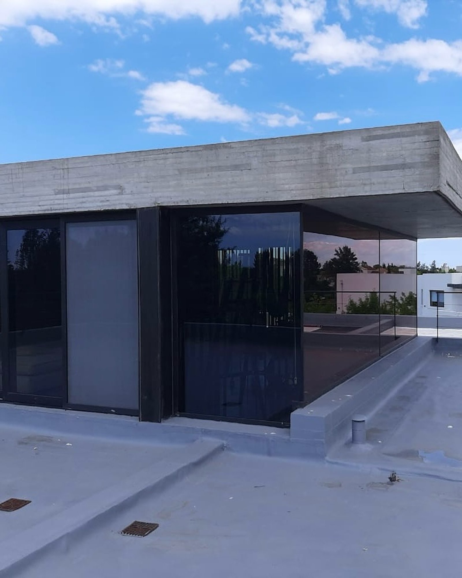 fachada moderna de hormigón y vidrio — proyecto FILMS 3M de control Solar, Seguridad y Privacidad, por Grupo Laminar 