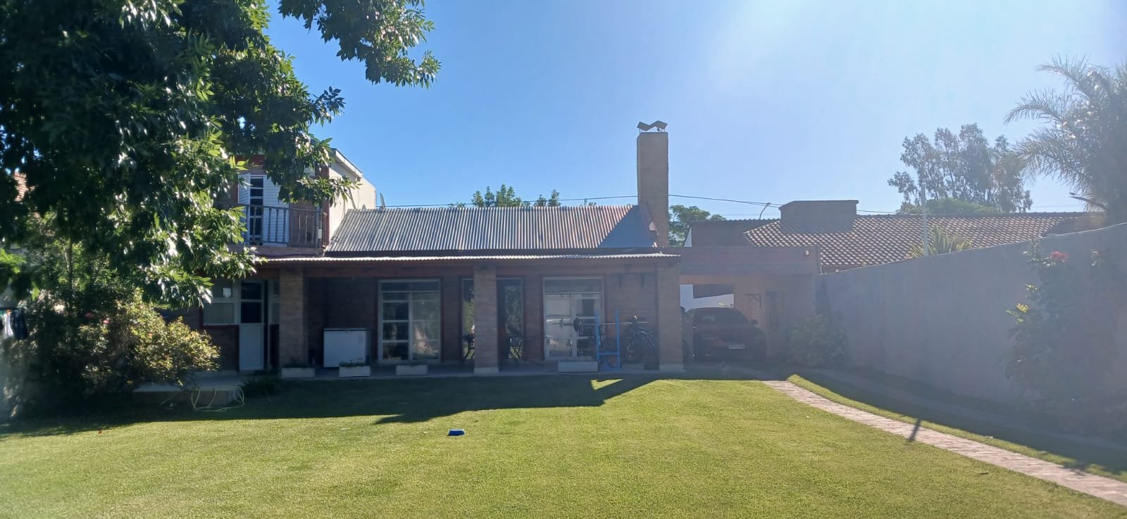 Casa moderna con césped amplio y porche cubierto — proyecto CASA ANDREA, por Amorosi Espacios de Diseño, en Neuquén