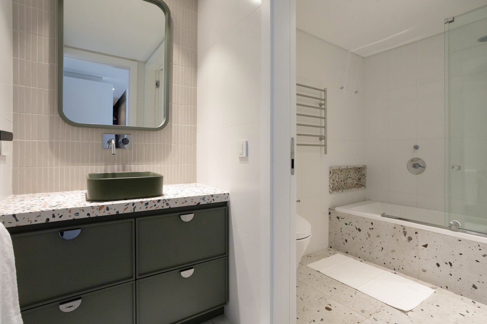 Baño moderno con mueble verde y espejo grande — proyecto Vidal, por Estudio Losa, en Belgrano