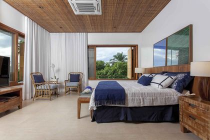 Dormitorio principal con cama king, ventanal tropical y techo madera — proyecto Quartos, por Xico Diniz