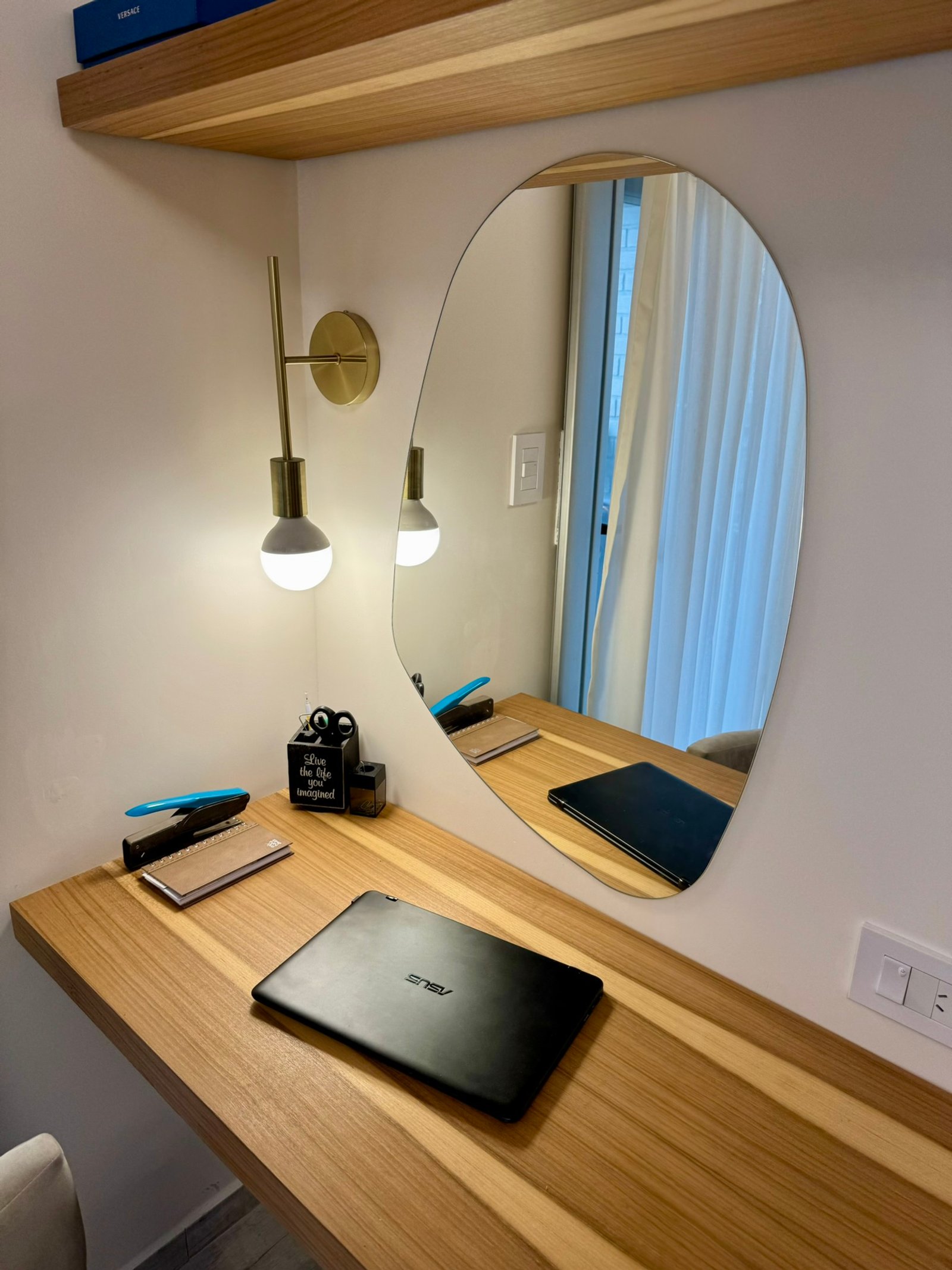 Oficina moderna con espejo irregular y luz de pared de latón — proyecto Corrientes I, por MDBK Arquitectura, en Villa Crespo