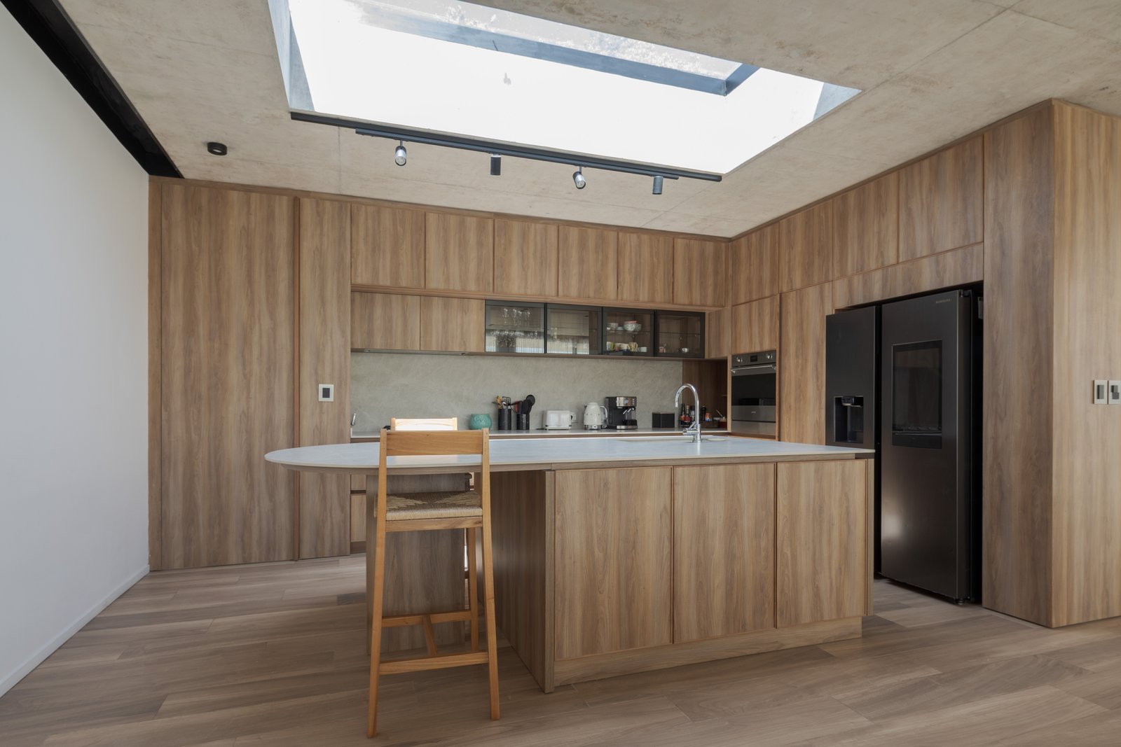 Cocina moderna con isla, luces empotradas y claraboya grande — proyecto Casa PLANALTO, por Grupo CRBN, en Av. Pres. Perón 10298