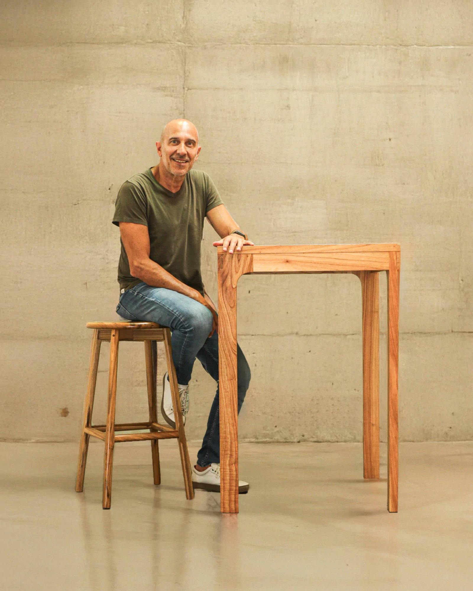 hombre sonriente en taburete junto a mesa de madera — proyecto Comedor, por BLVD Furniture
