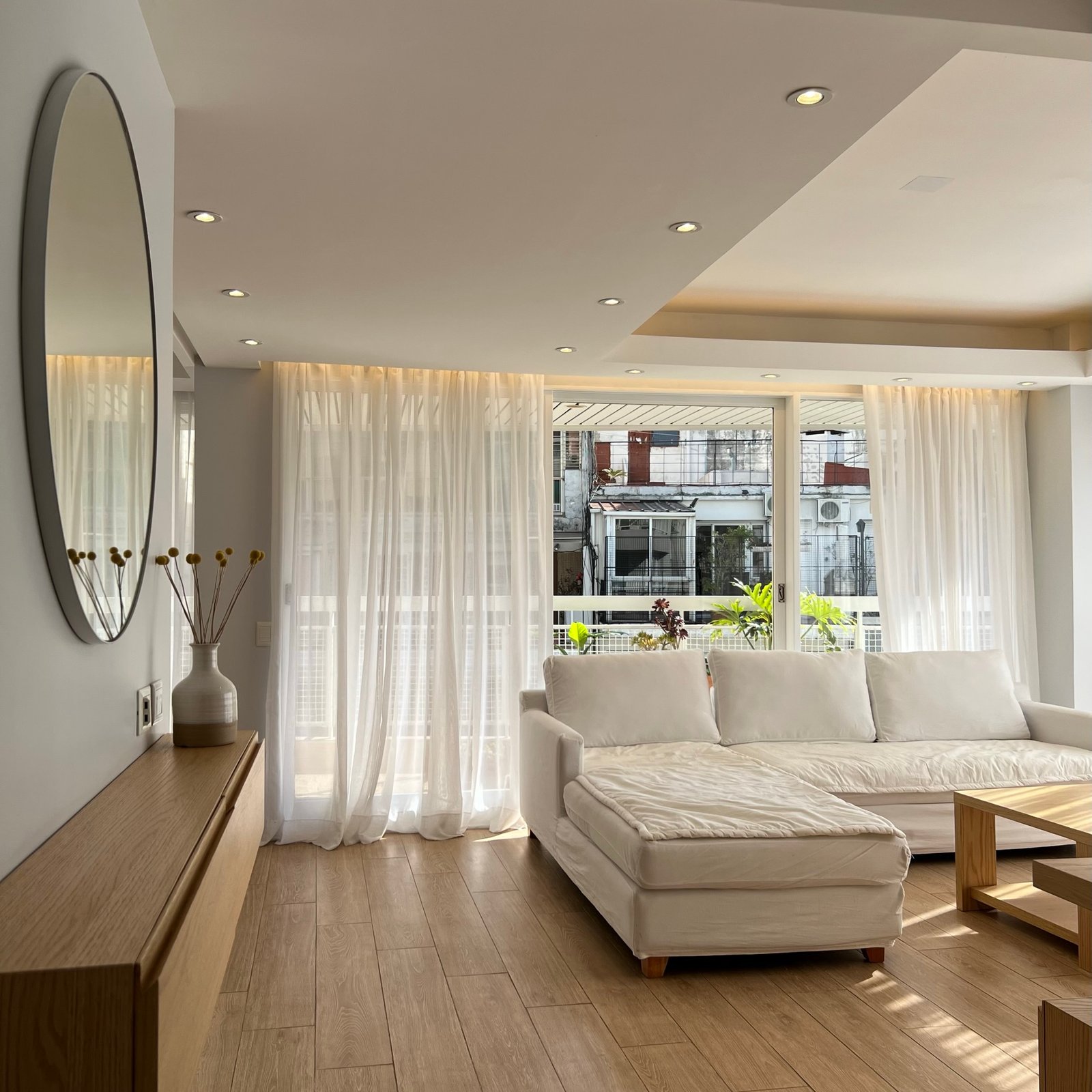 Sala moderna com cortinas brancas e sofá bege — projeto Araoz, por MDBK Arquitectura, em Palermo