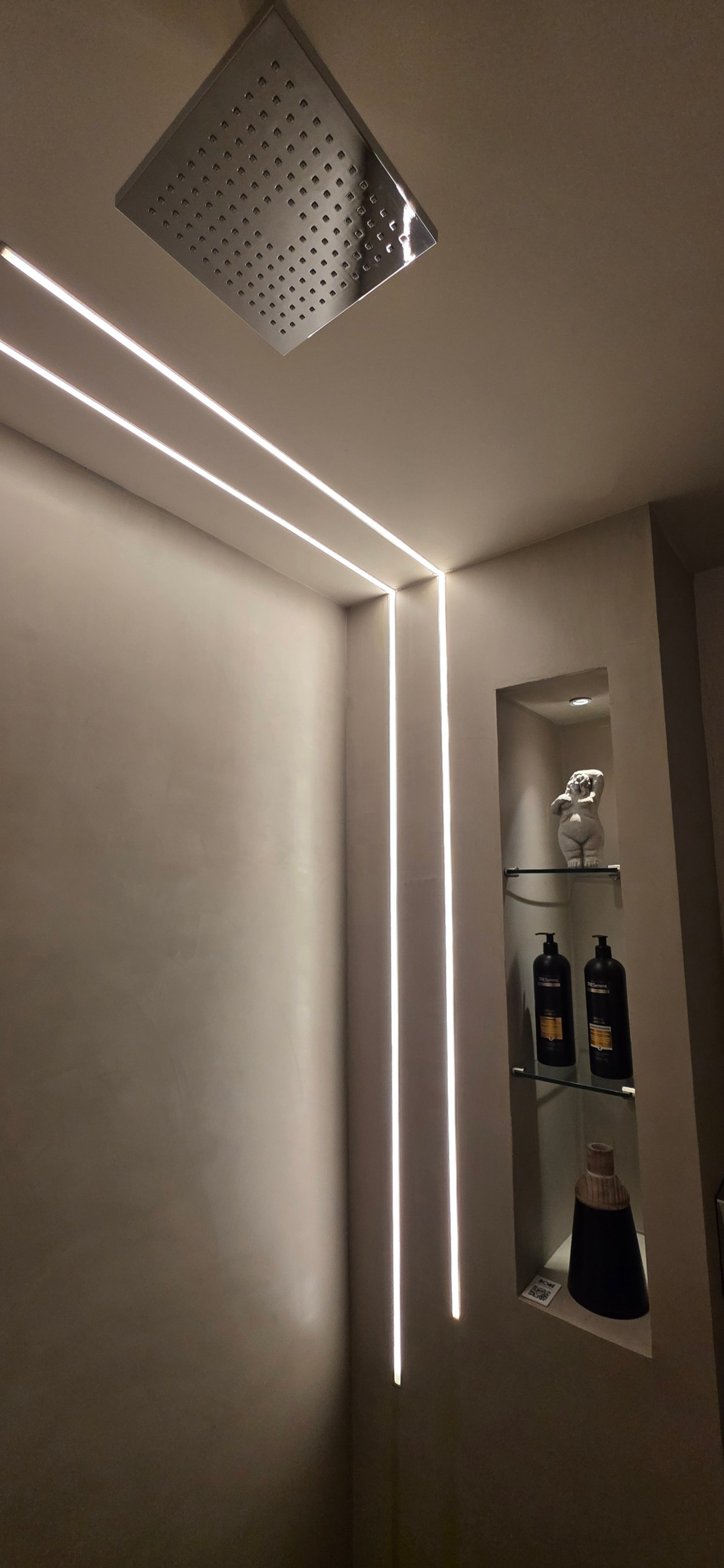 Banheiro moderno com iluminação linear embutida e prateleiras recuadas — projeto Baño en suite sencualidad natural UNE 2026 Posadas Misiones, por Matec ss, em Posadas
