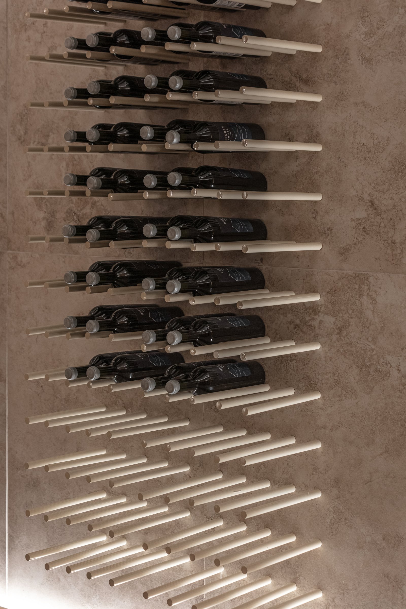 adega moderna com prateleiras de metal preto e garrafas de vinho — projeto Casa Foa 2025 | Degustando experiencias | Tasting experiences | Lucia Quinteros, por Ren Studio, em Cdad.