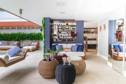 Living moderno con jardín vertical, muebles de ratán y paleta azul blanca — proyecto Casa Barra ED, por Amanda Miranda