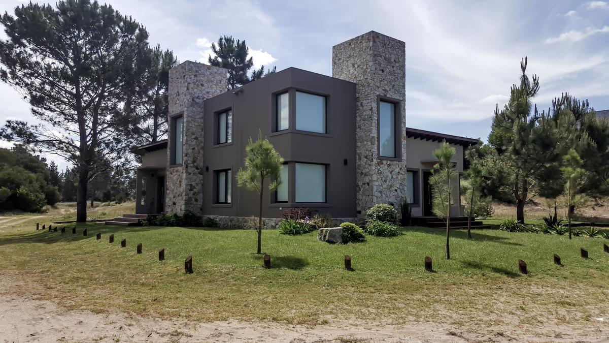 Casa moderna con torres de piedra y grandes ventanales — proyecto Vivienda Multifamiliar en Las Gaviotas, por Estudio Schifano, en Canning