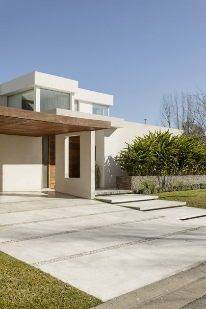 Casa moderna blanca con pergola de madera y patio de hormigón pulido — proyecto Santa Barbara 121, por Build a Home Arquitectura, en B1648 Tigre