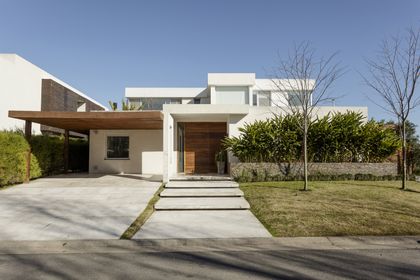 Casa moderna blanca con pergola de madera y jardín minimalista — proyecto Santa Barbara 121, por Build a Home Arquitectura, en B1648 Tigre