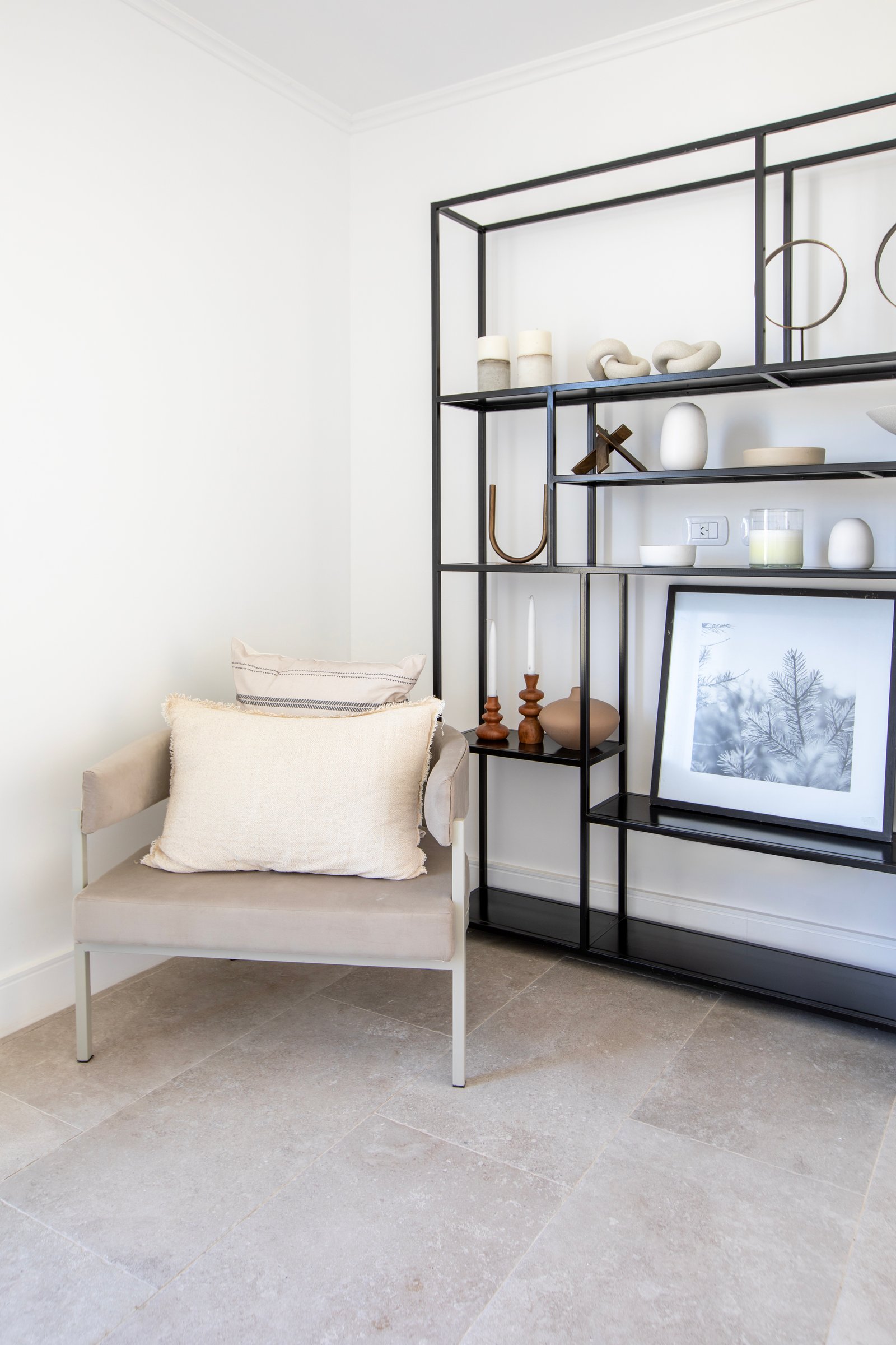 Living con sillon minimalista y estanteria metalica — proyecto OBRA LE PIETRE DEL CASALE SABBIA, por ILVA, en Provincia de Buenos Aires