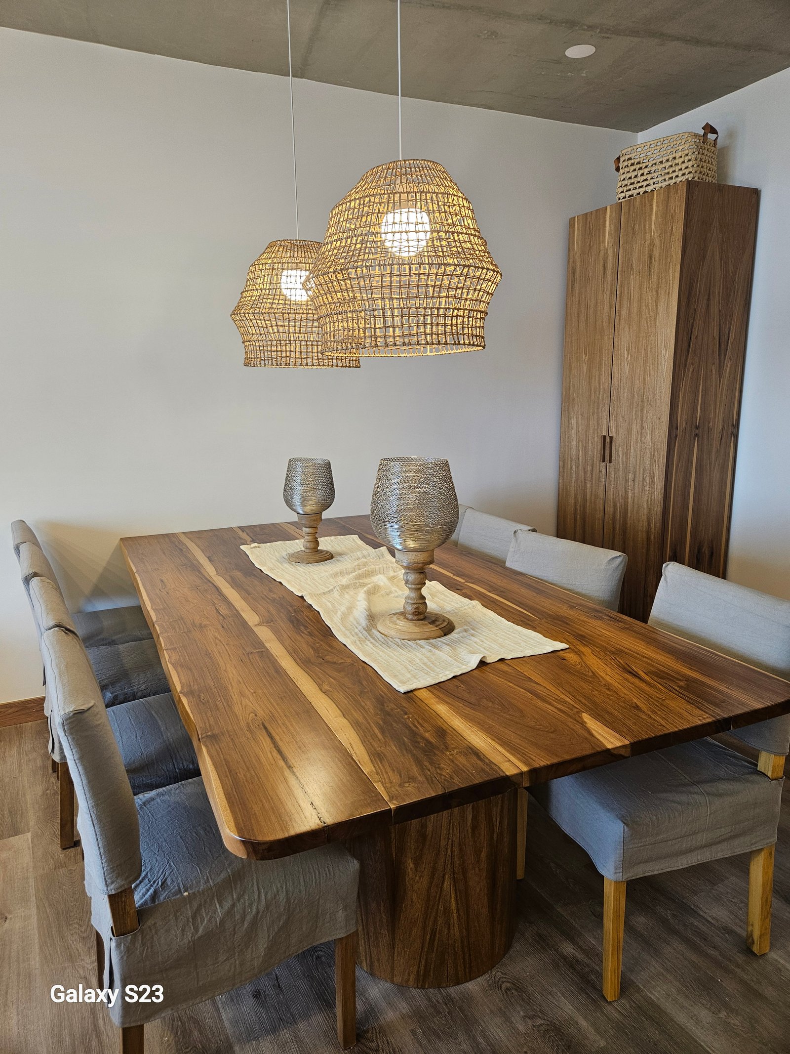 Comedor rústico con mesa de madera y lámparas de mimbre — proyecto North Beach, por reginahallba5284, en Provincia de Buenos Aires