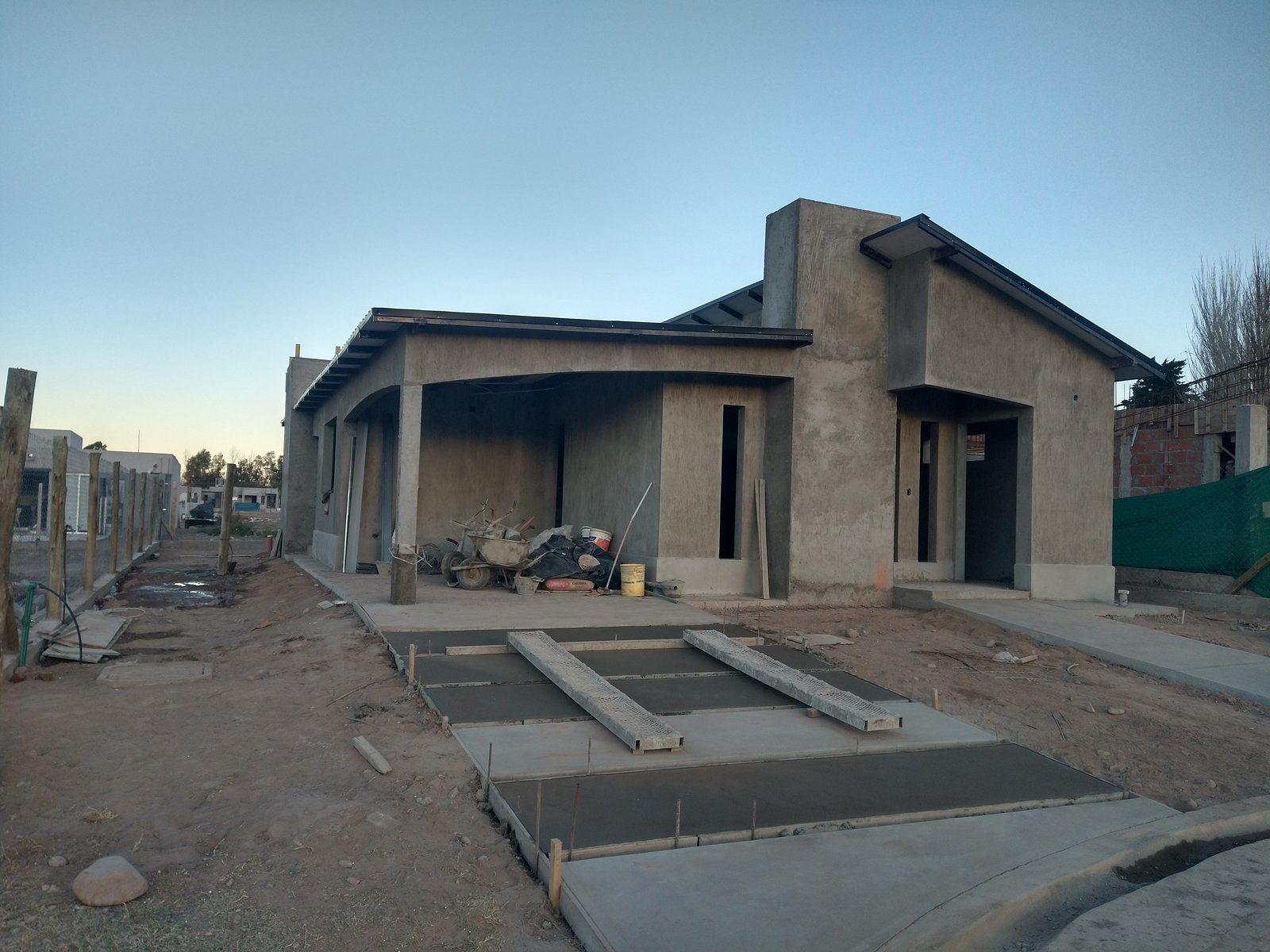 casa en construcción con fachada de hormigón visto — proyecto Proyecto R-M, por TERROC, en Maipú