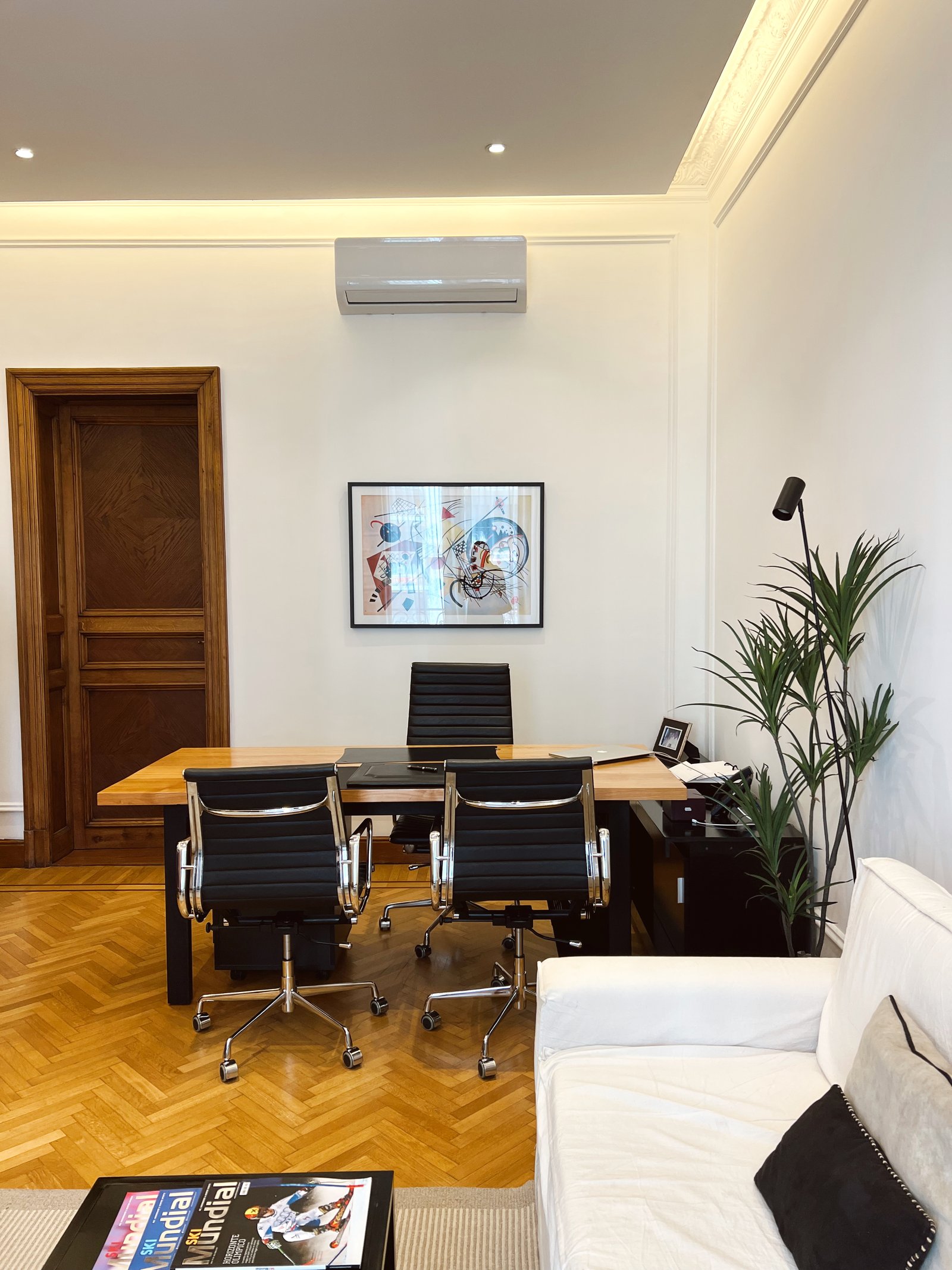 Oficina moderna con pisos de madera y sofá blanco — proyecto MONTEVIDEO, por Estudio RG, en Recoleta