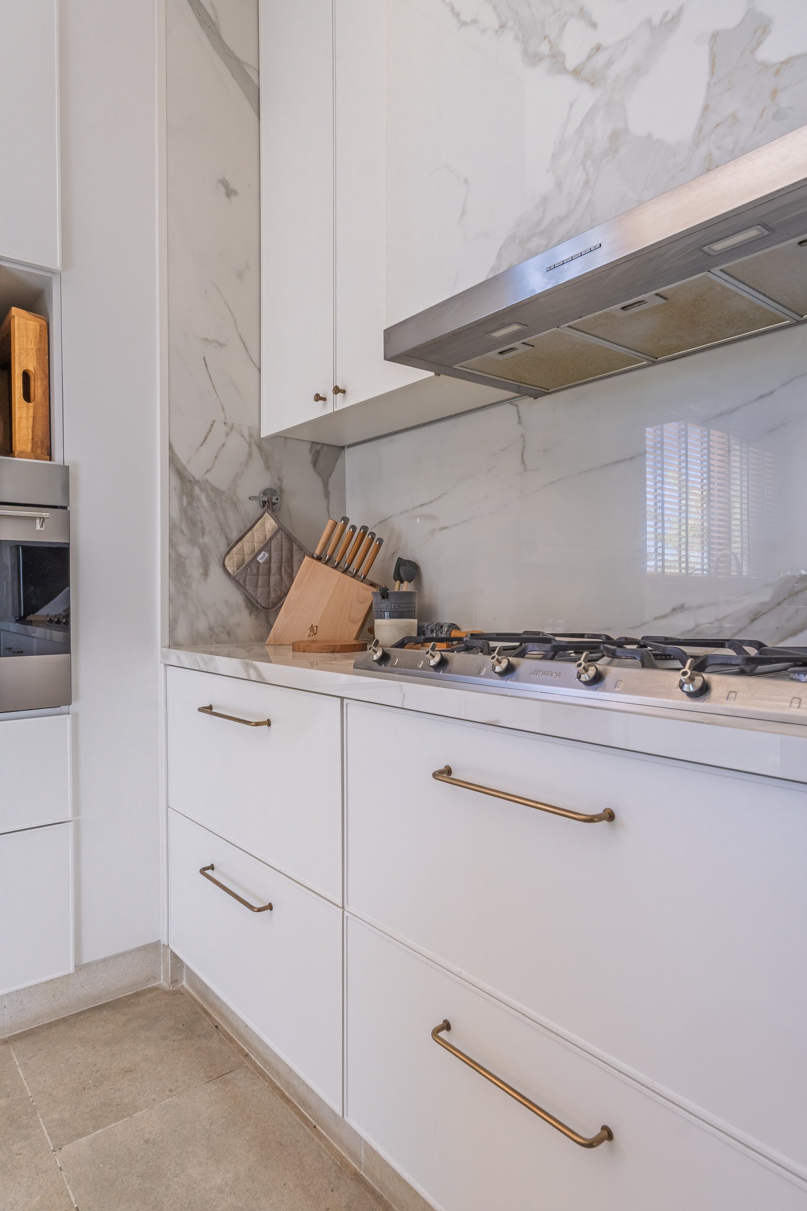 Cocina moderna con acabados en mármol y latón — proyecto PilarA - Estudio Pacifica, por ABEJA CONCEPT, en Pilar
