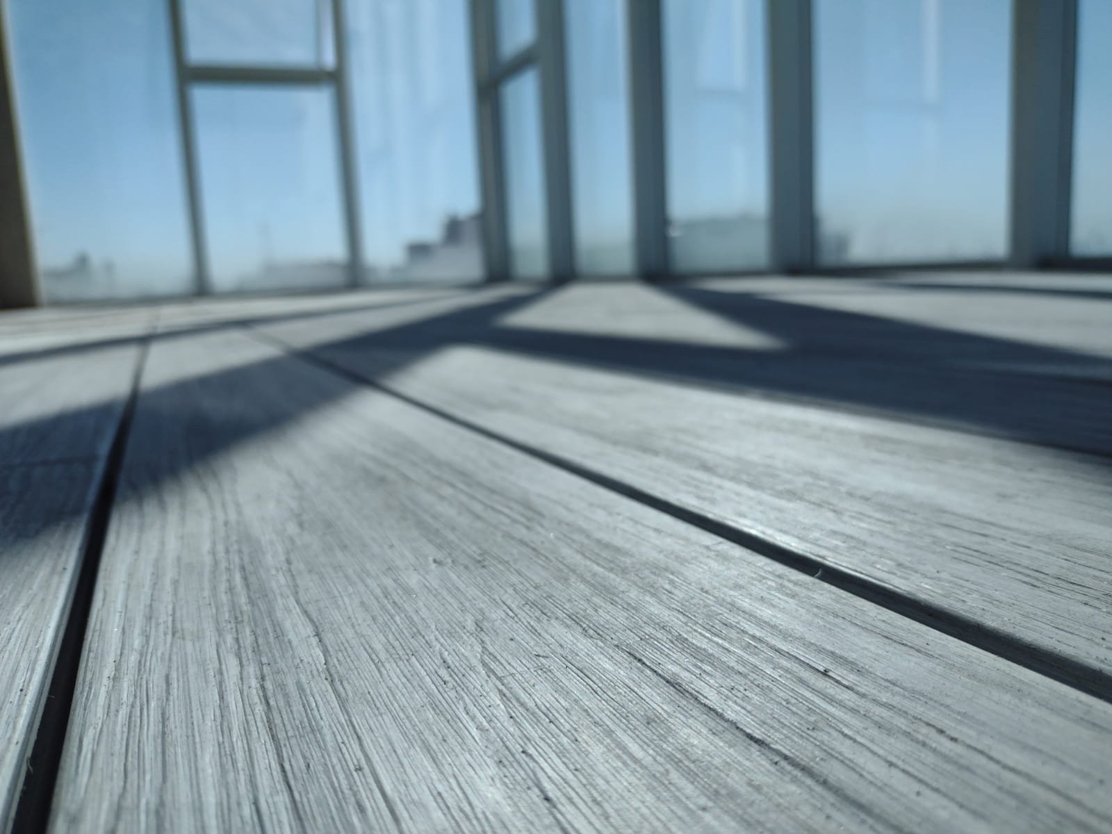 Terraza moderna con deck de madera y sombras de sol — proyecto Outdoor, por The Flooring Company
