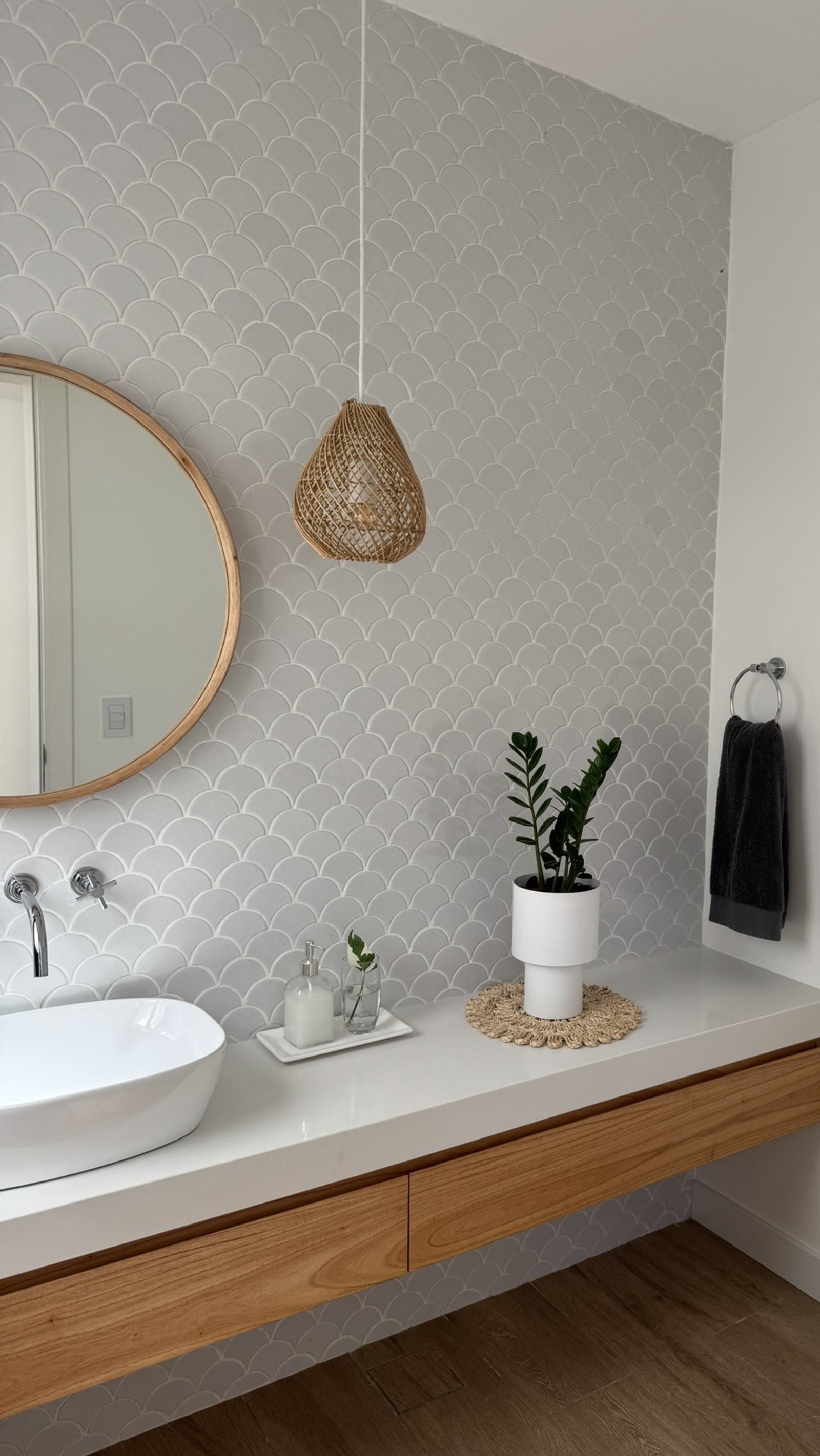 Baño moderno con pared de azulejos grises en forma de abanico y vanitory de madera flotante — proyecto Casa MC, por Hermann Arquitectos, en Bv. Central