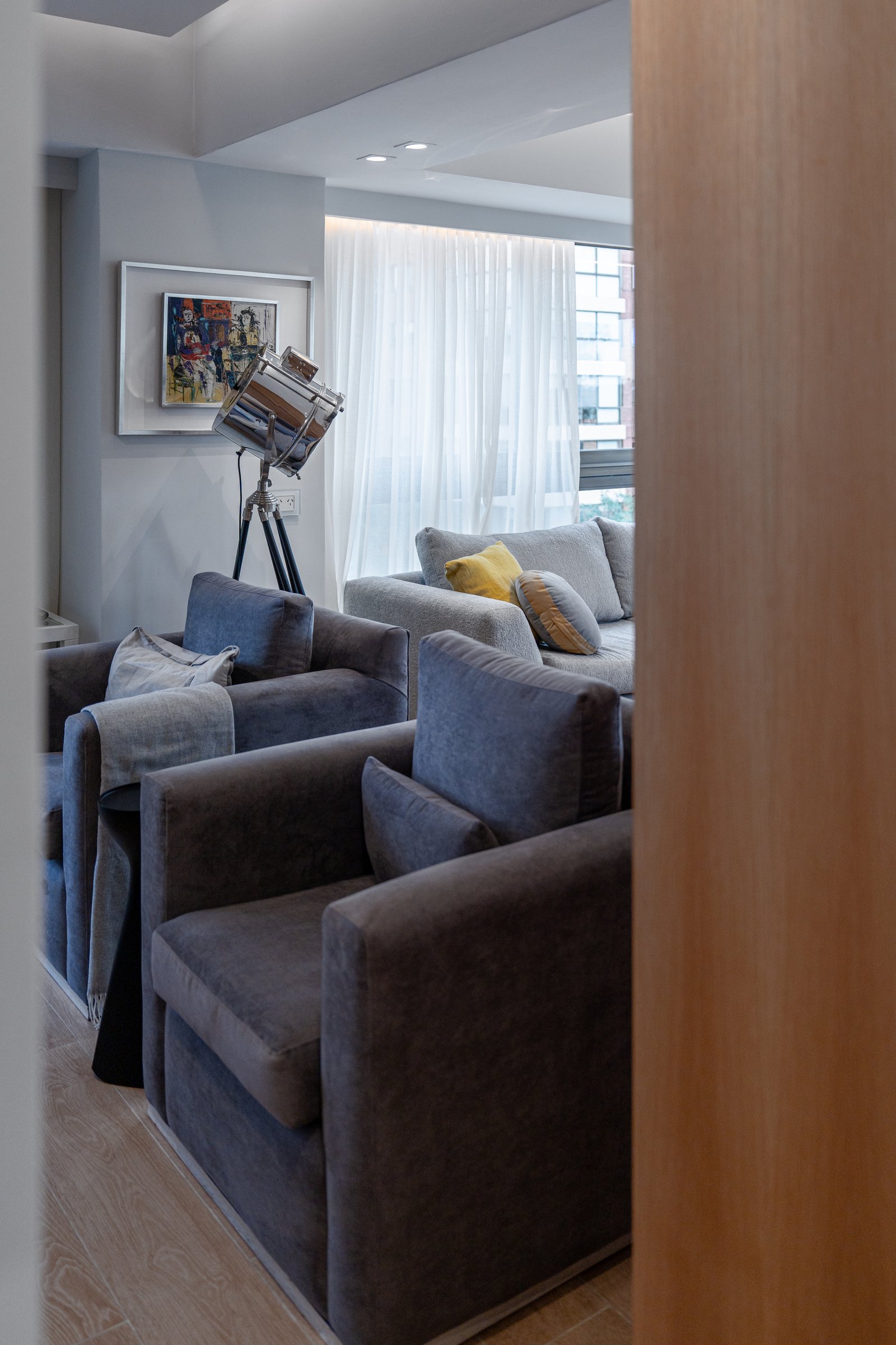 Living moderno con sillones grises, lámpara industrial y cortinas blancas — proyecto Sucre, por KUPERDESIGN CONSTRUCCIONES SRL, en Mcal. Antonio José de Sucre 755