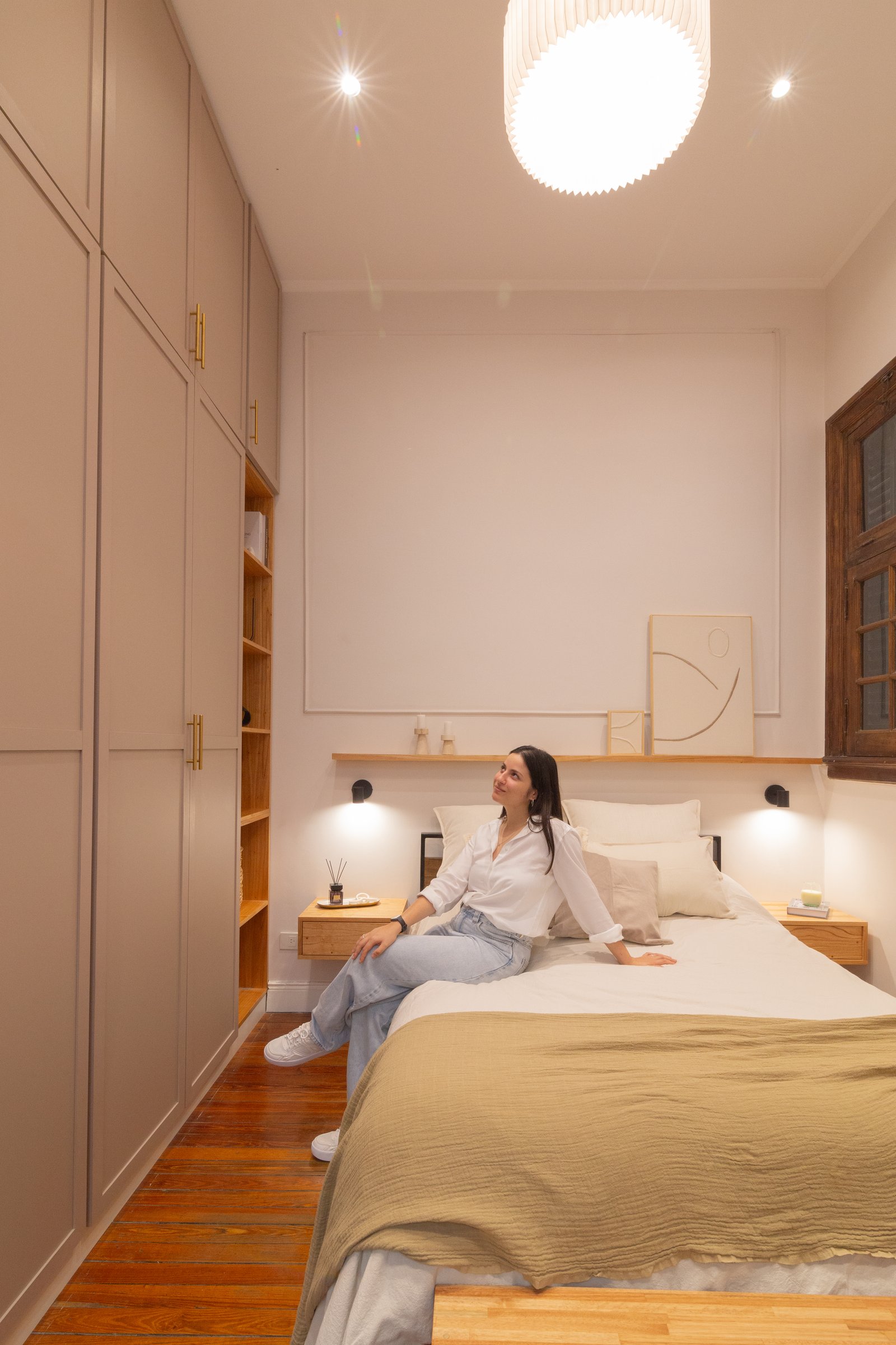 quarto moderno com armário embutido e grande luminária pendente — projeto Anchorena, por Martina Kleinert, em Palermo