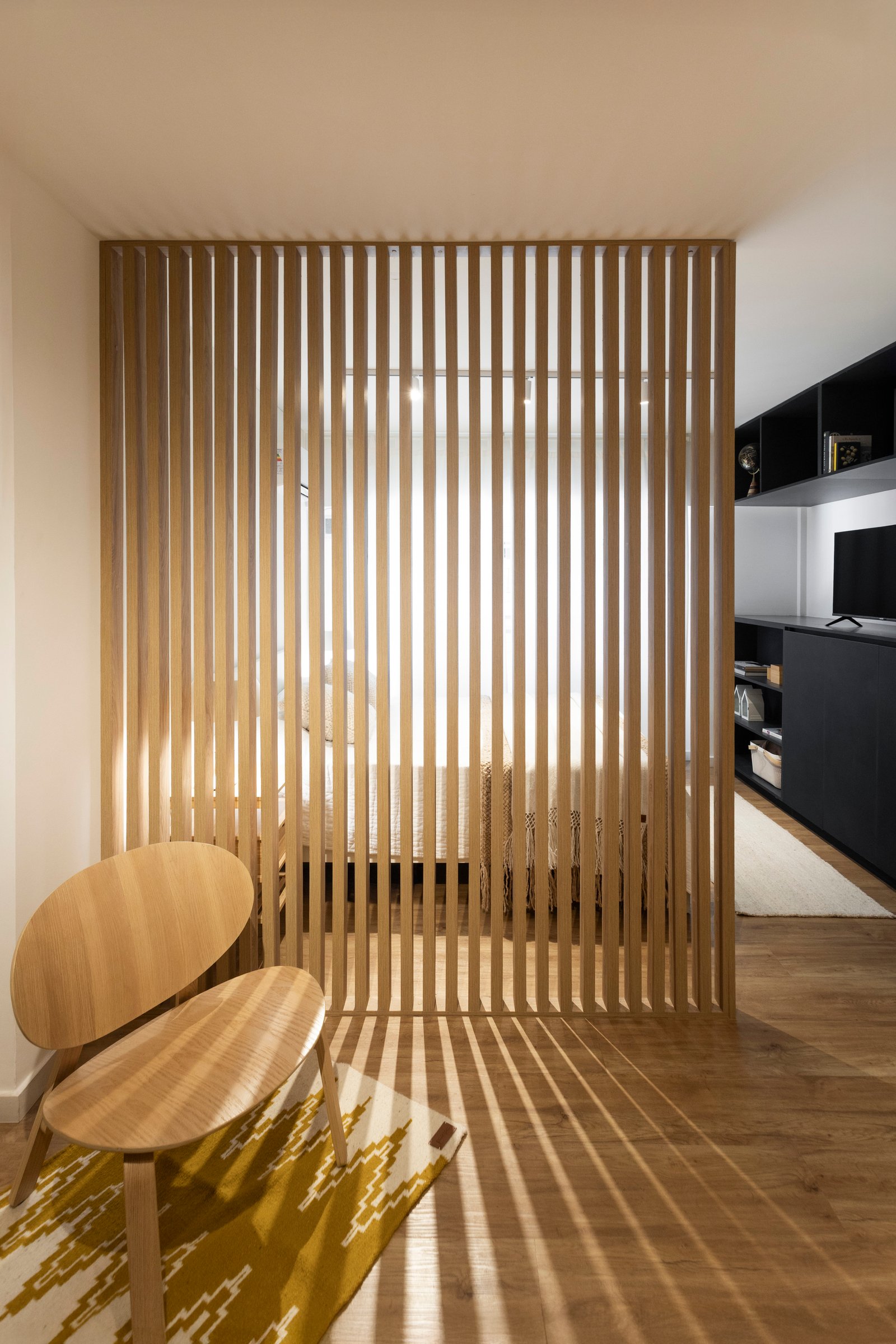 Quarto moderno com divisor de madeira e iluminação indireta — projeto REFORMA NE, por Rastro Estudio, em Palermo