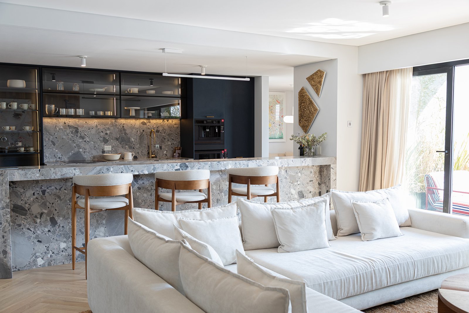 Cocina moderna integrada a living, isla de mármol y sofá beige — proyecto Pia Magri, por Gaby Alfonso, en B1648 Tigre