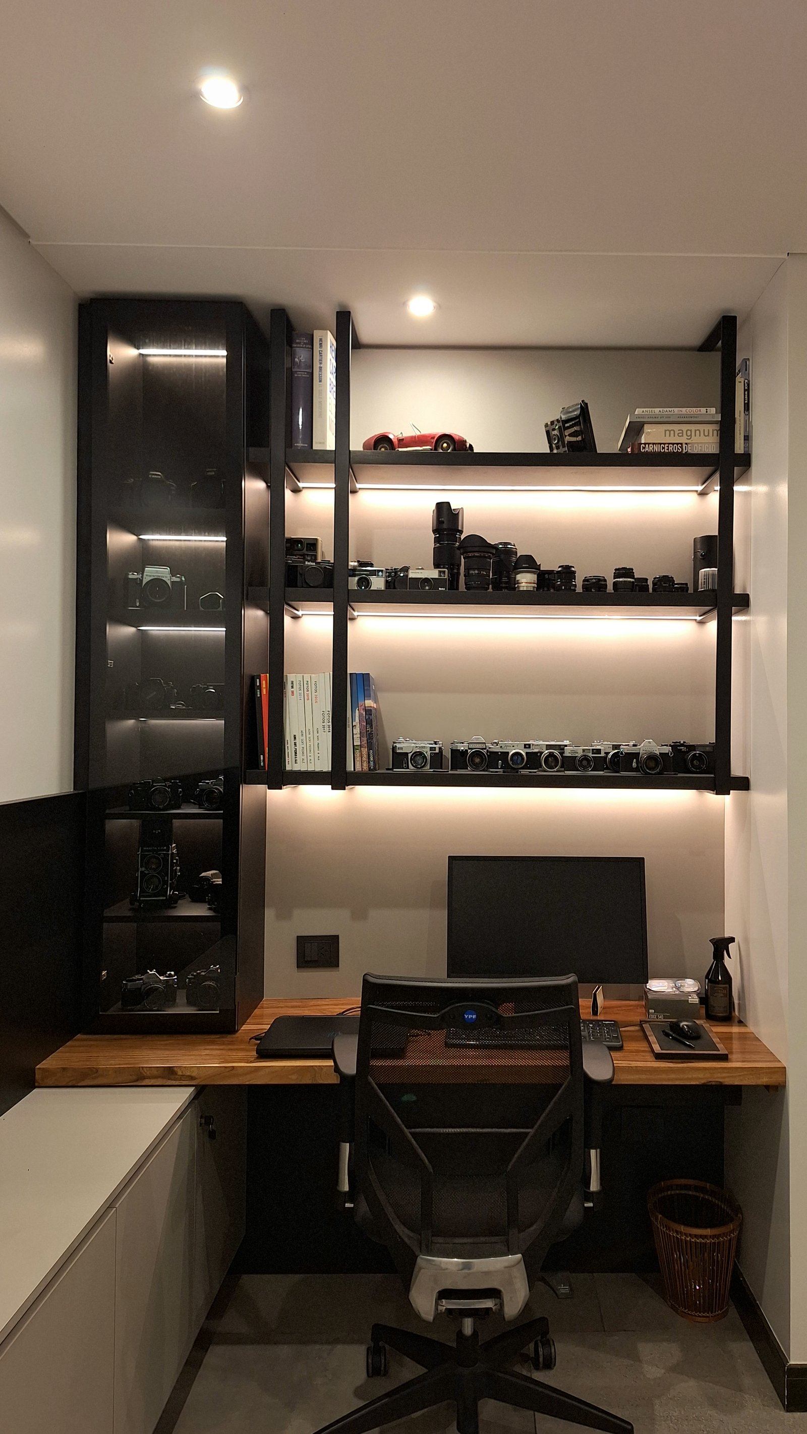 Oficina moderna con estanterías negras y escritorio de madera — proyecto PROYECTO MUELLES, por HALESA ESTUDIO, en Av. de los Lagos