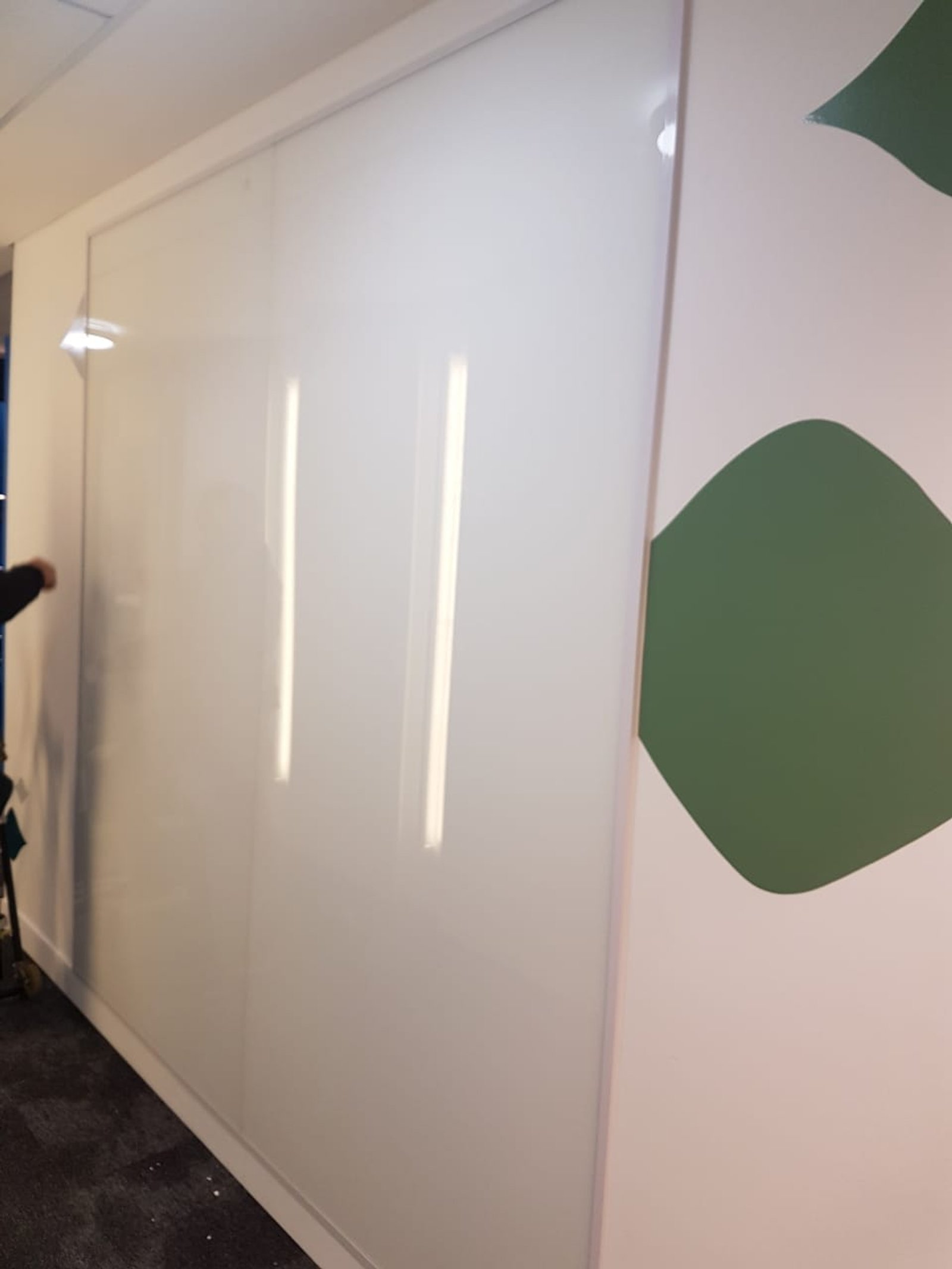 pared de vidrio blanco brillante y arte abstracto verde en oficina moderna — proyecto Coverglass laminado 3+3 blanco, por Cristalcenter, en Retiro