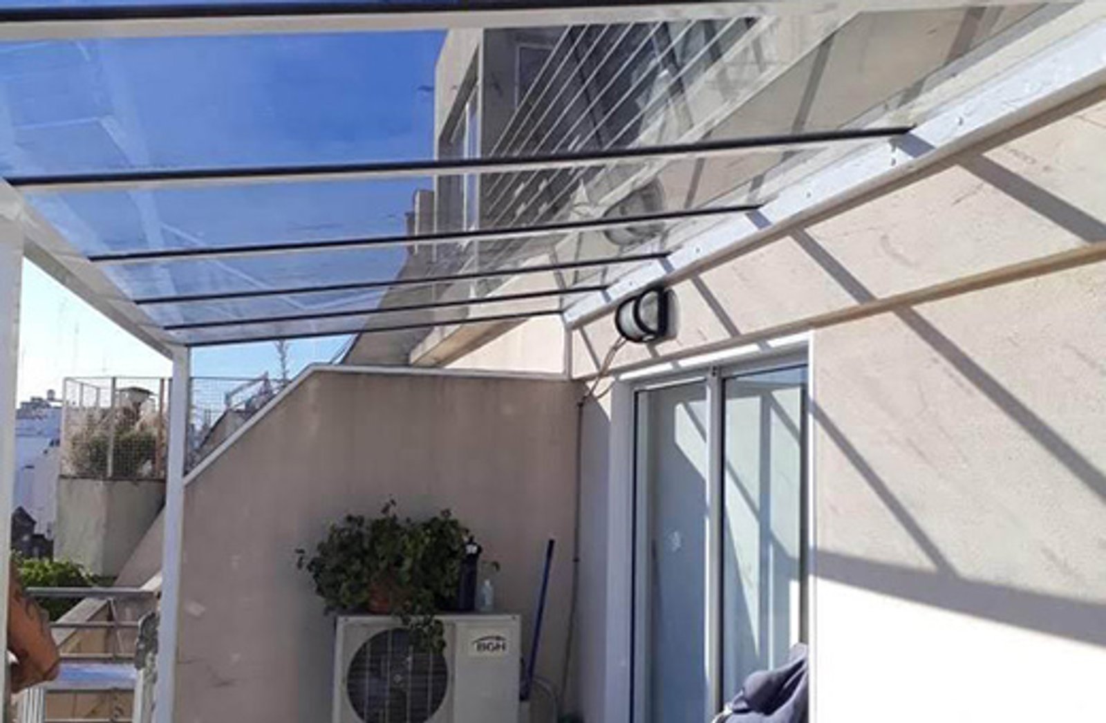 Terraço de apartamento moderno com cobertura de vidro e plantas — projeto Techos en vidrio laminado, por Cristalcenter, em Parque Leloir