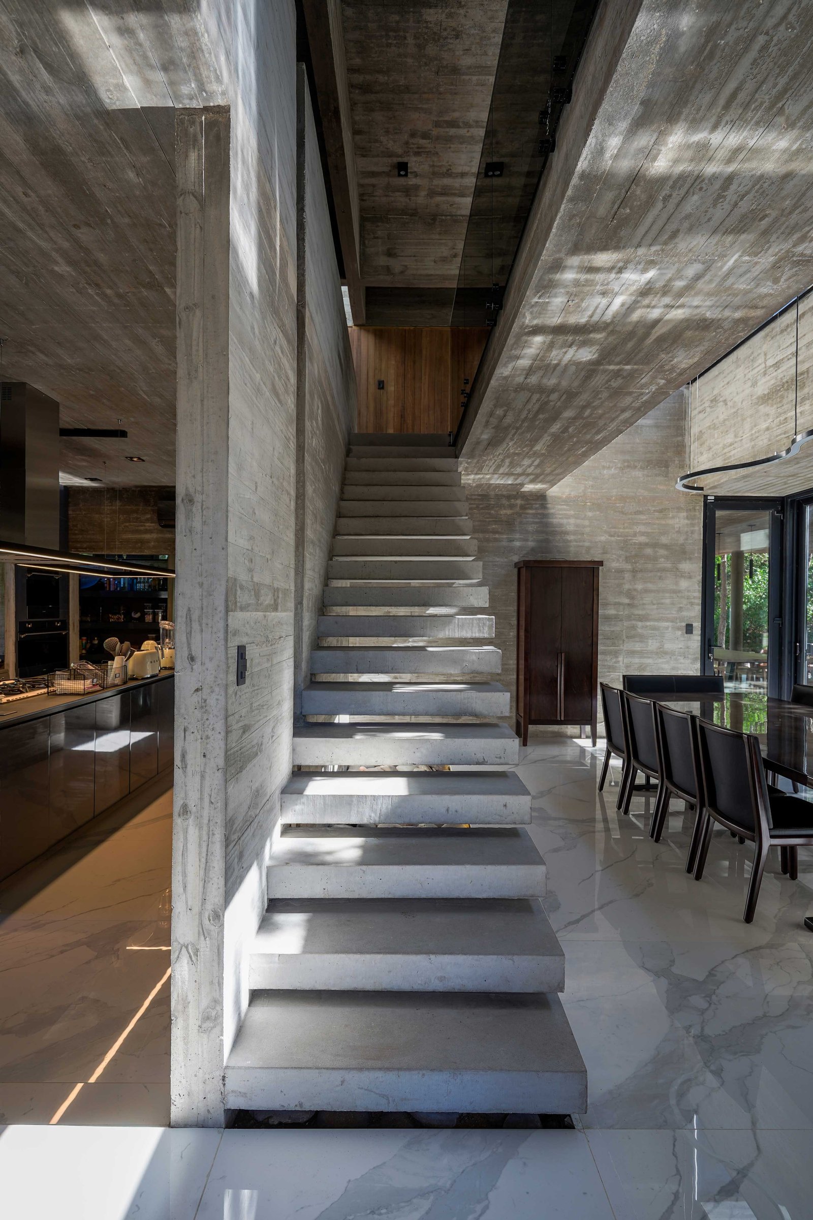 Escalera flotante de hormigón visto en interior moderno y brutalista — proyecto Casa 4H, por Besonías Almeida arquitectos, en X6VF+67