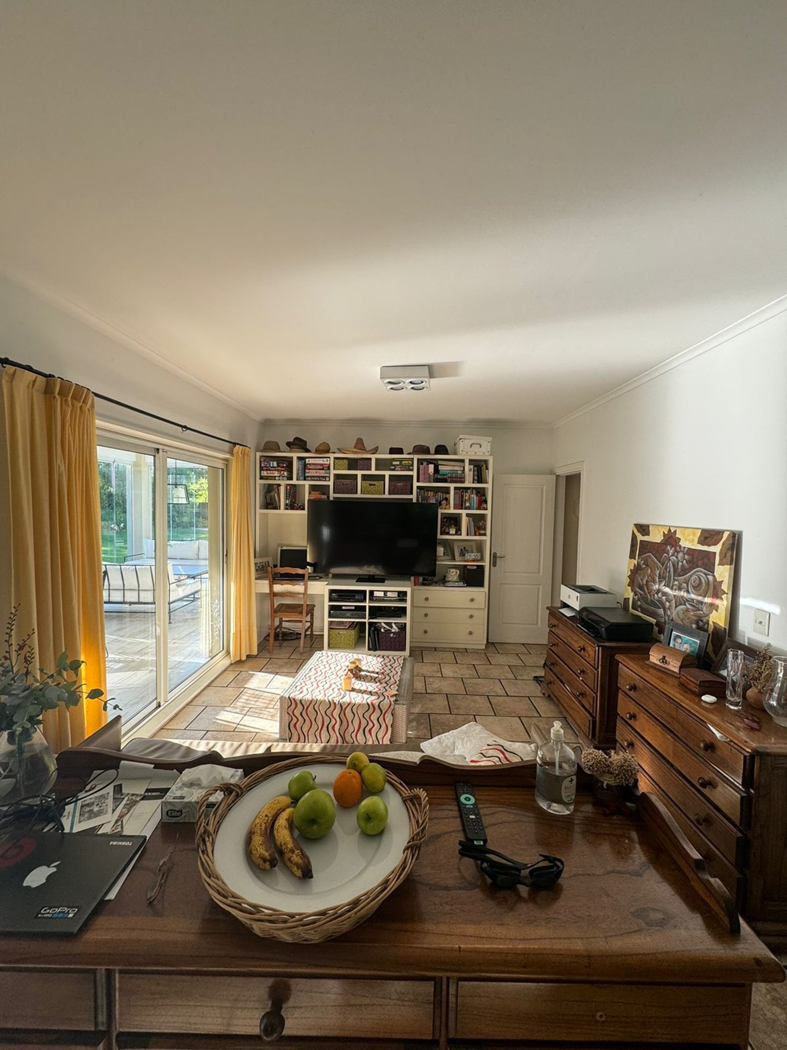 Living con estanterías integradas y mucha luz natural — proyecto La rinconada, por Casa Fi, en Pilar