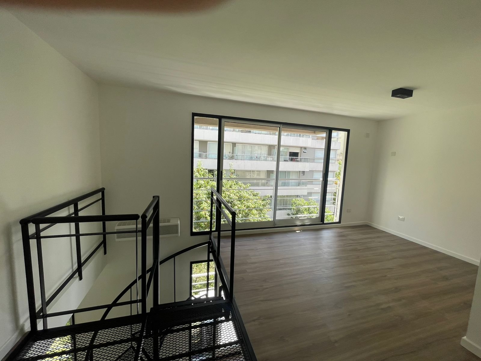 Escalera flotante moderna con grandes ventanales y vista urbana — proyecto Jorge Newbery , por Estudio NET Arquitectura , en Av. Jorge Newbery 1820