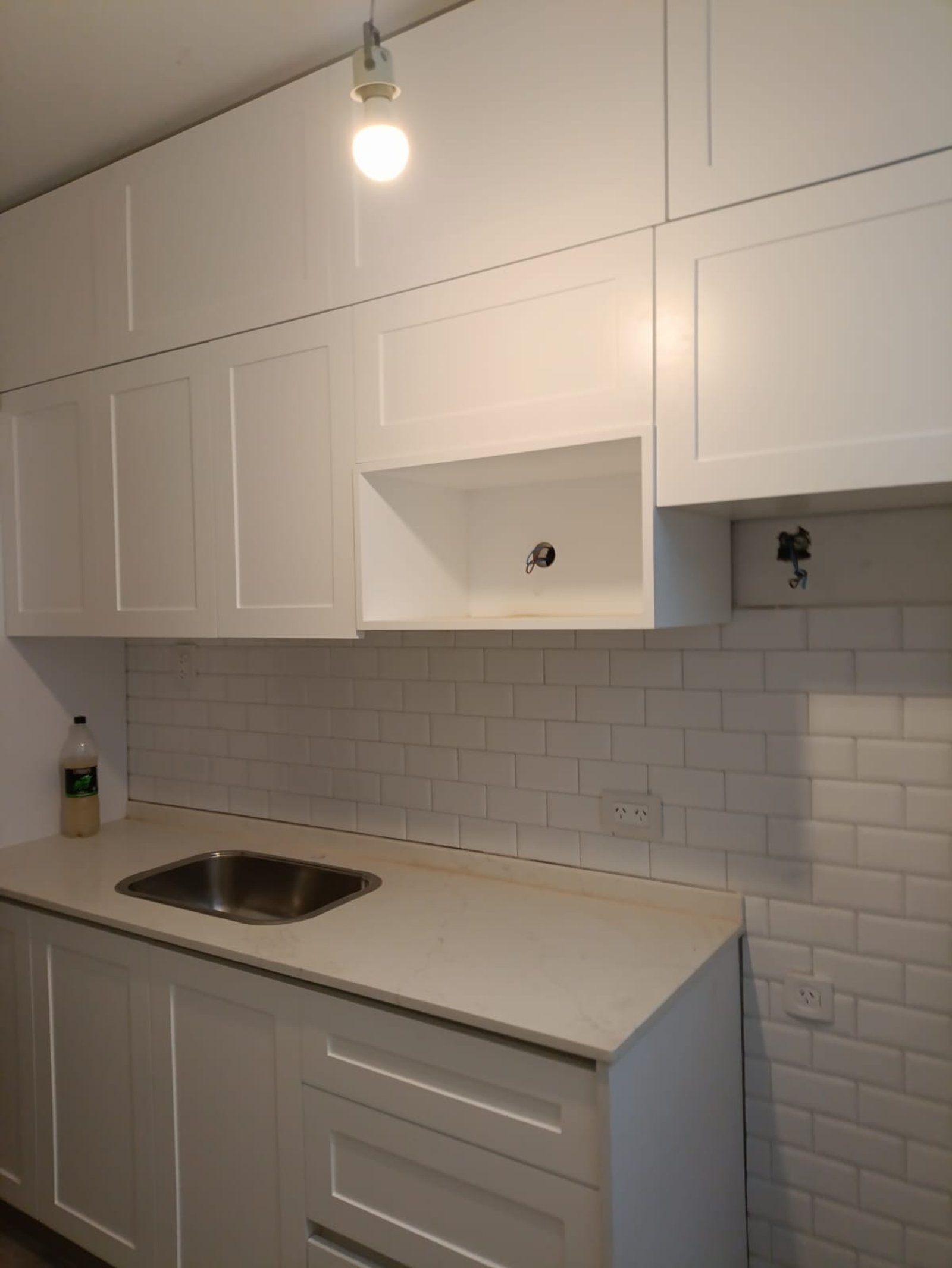 Cocina moderna blanca con azulejos blancos y mesada de piedra beige — proyecto NEUQUEN, por Licefe Carpentry SRL, en Caballito