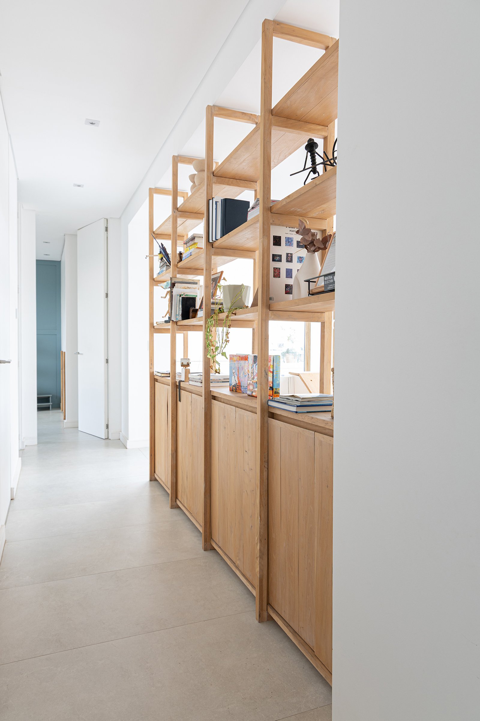 Estantería y almacenamiento de madera natural en pasillo moderno — proyecto Casa Al Agua - Grupo PAUTA, por Gaby Alfonso, en Belén de Escobar