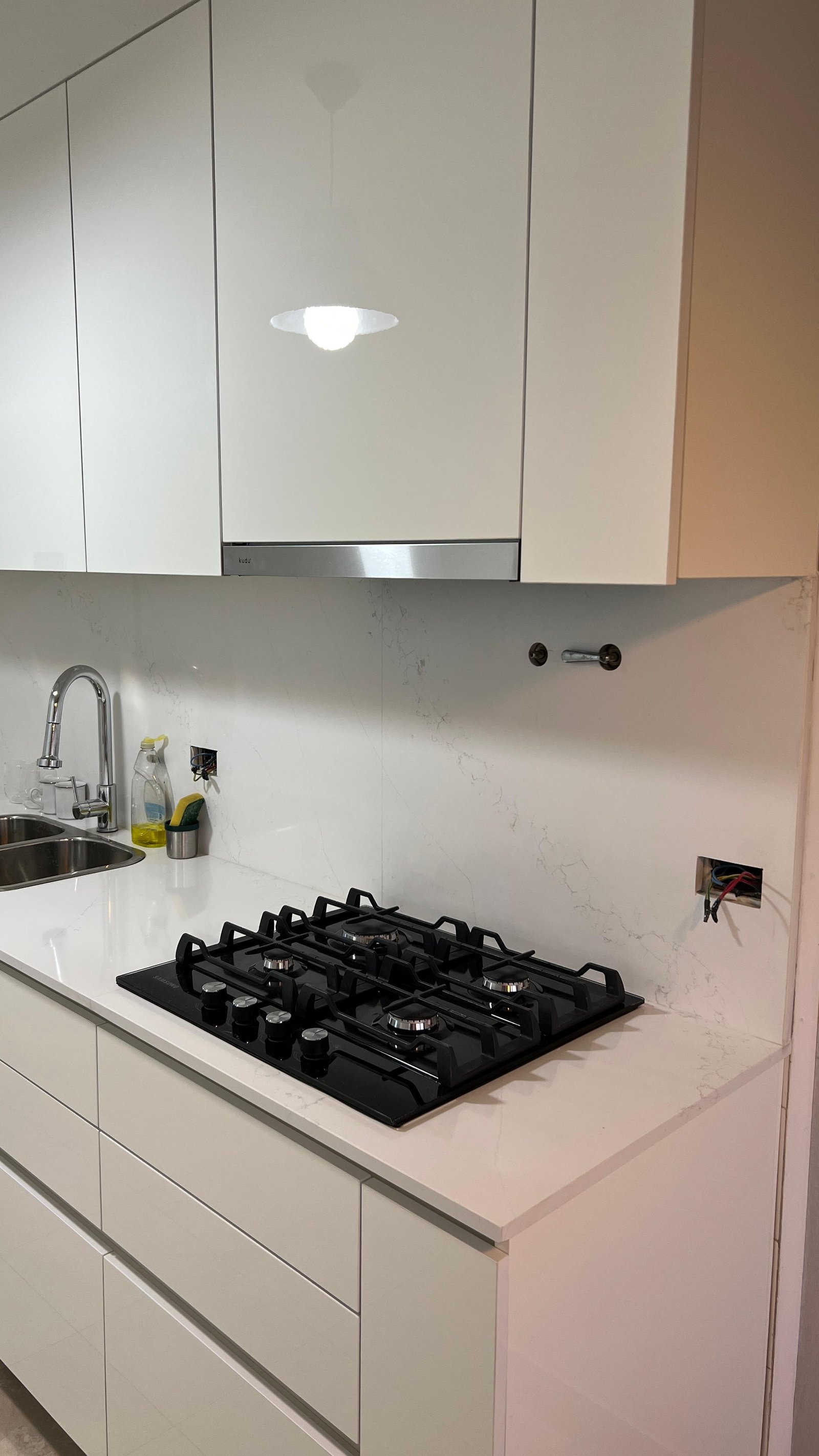 Cozinha moderna branca minimalista com ilha e eletrodomésticos embutidos — projeto Cocina con frentes en rousbicio blanco, por Carpinteria Tientta, em Puerto Madero