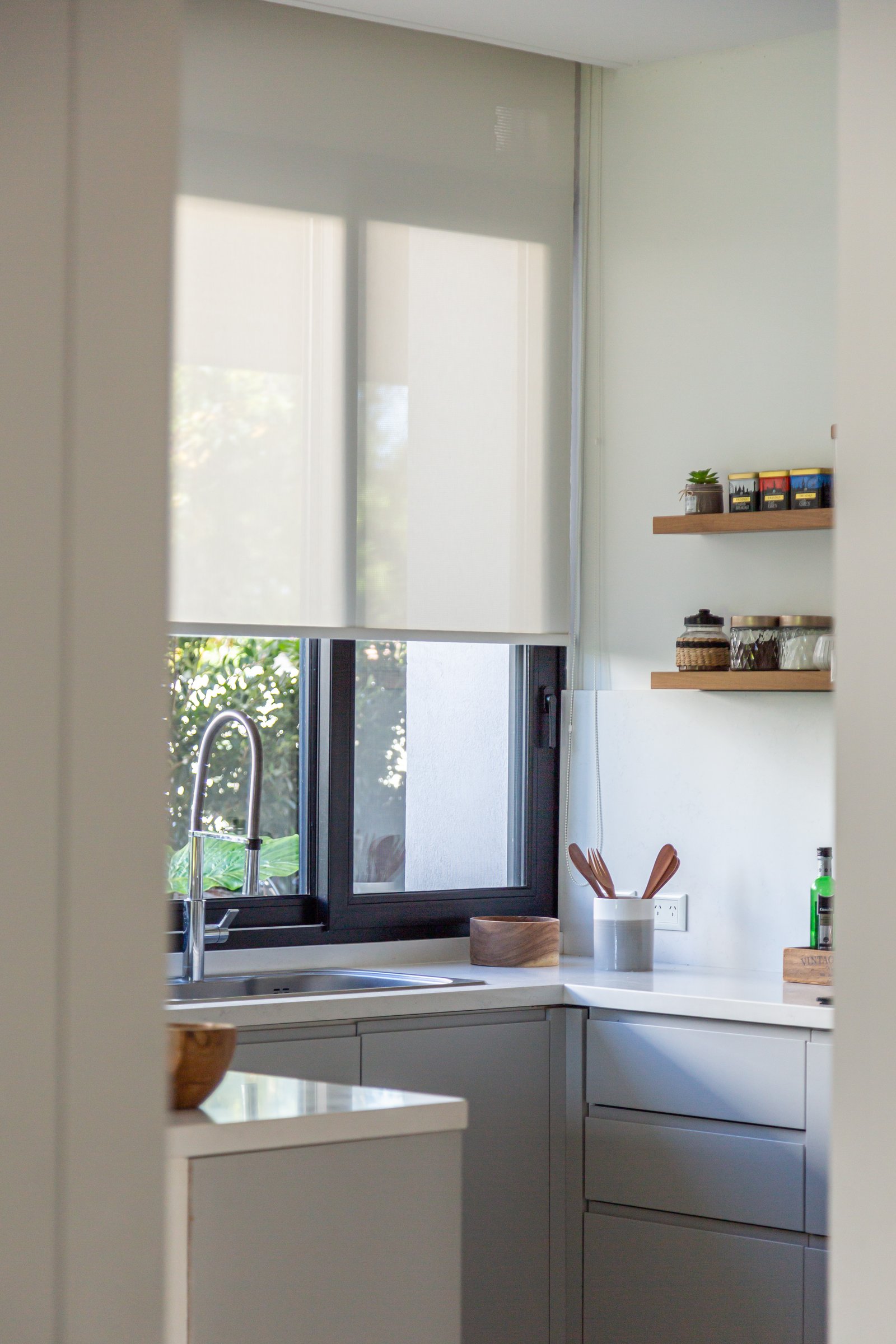 Cocina moderna con persianas blancas y gabinetes grises — proyecto CUBA 110, por Poce Arquitectura, en B1633 Fátima