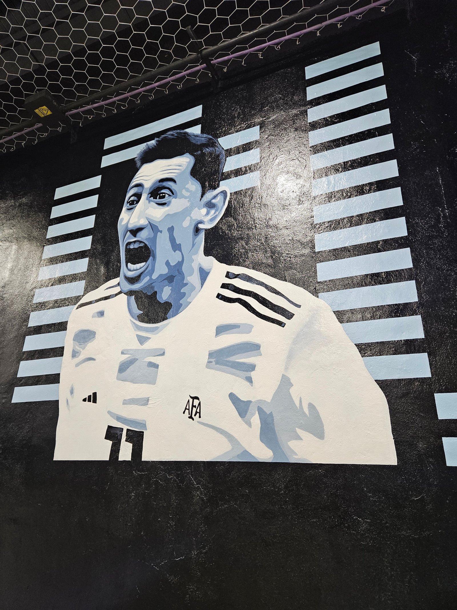 mural de futbolista argentino en pared exterior — proyecto CLUB AERA, por UN.MURAL, en Villa Lynch