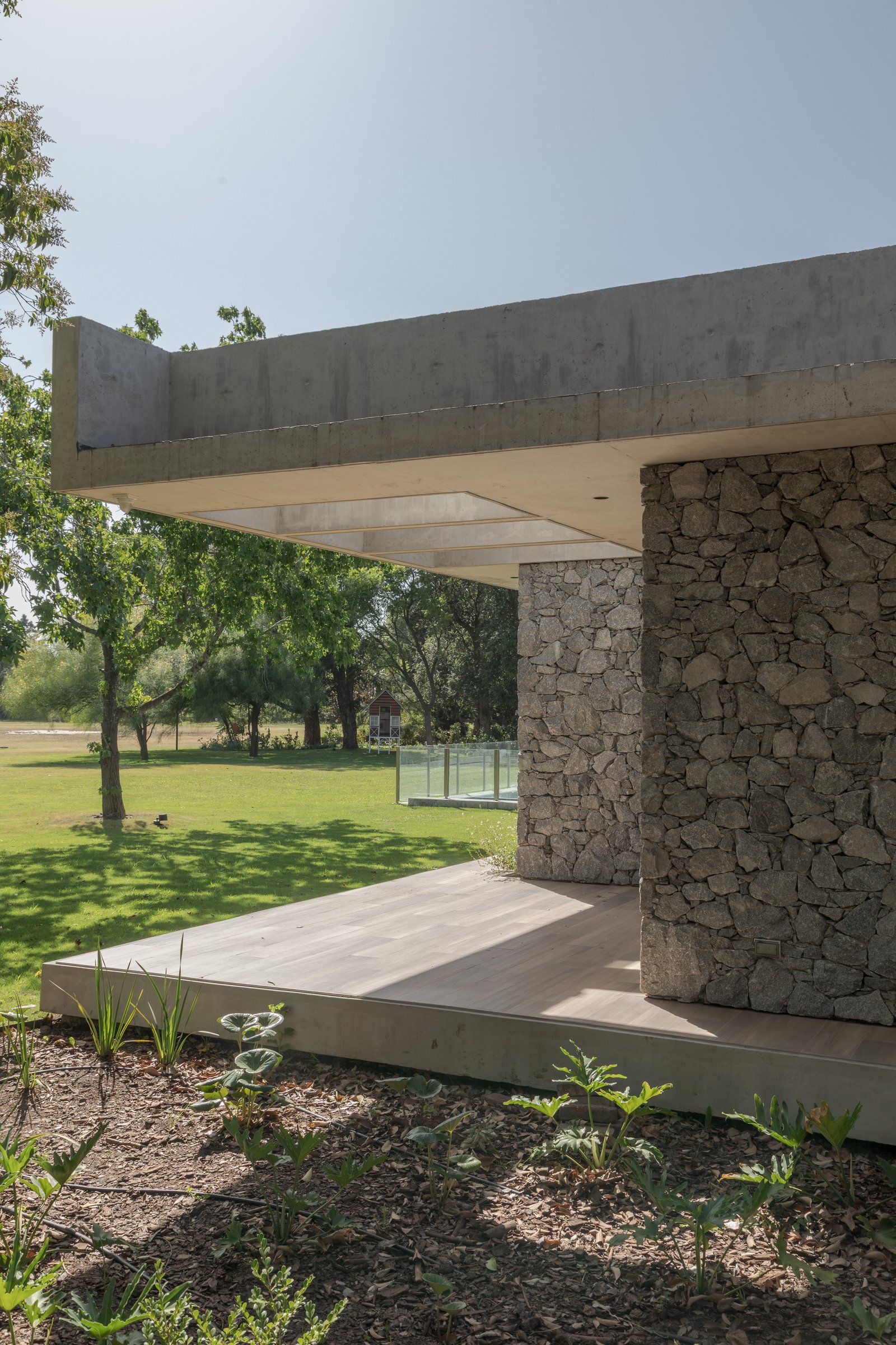 Fachada moderna con piedra apilada y voladizo de hormigón — proyecto Casa PLANALTO, por Grupo CRBN, en Av. Pres. Perón 10298