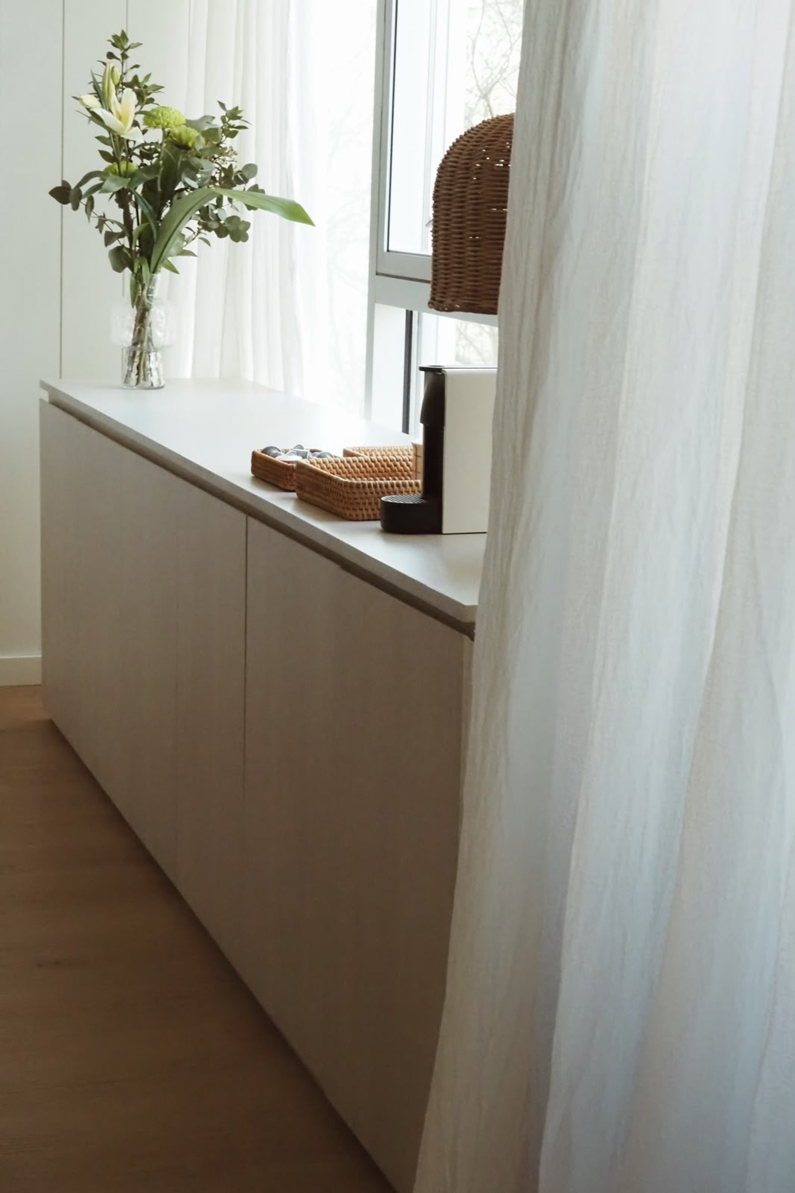 Mueble bajo beige integrado con plantas y cafetera, luz natural — proyecto PICO, por APATHEIA, en Cdad. Autónoma de Buenos Aires
