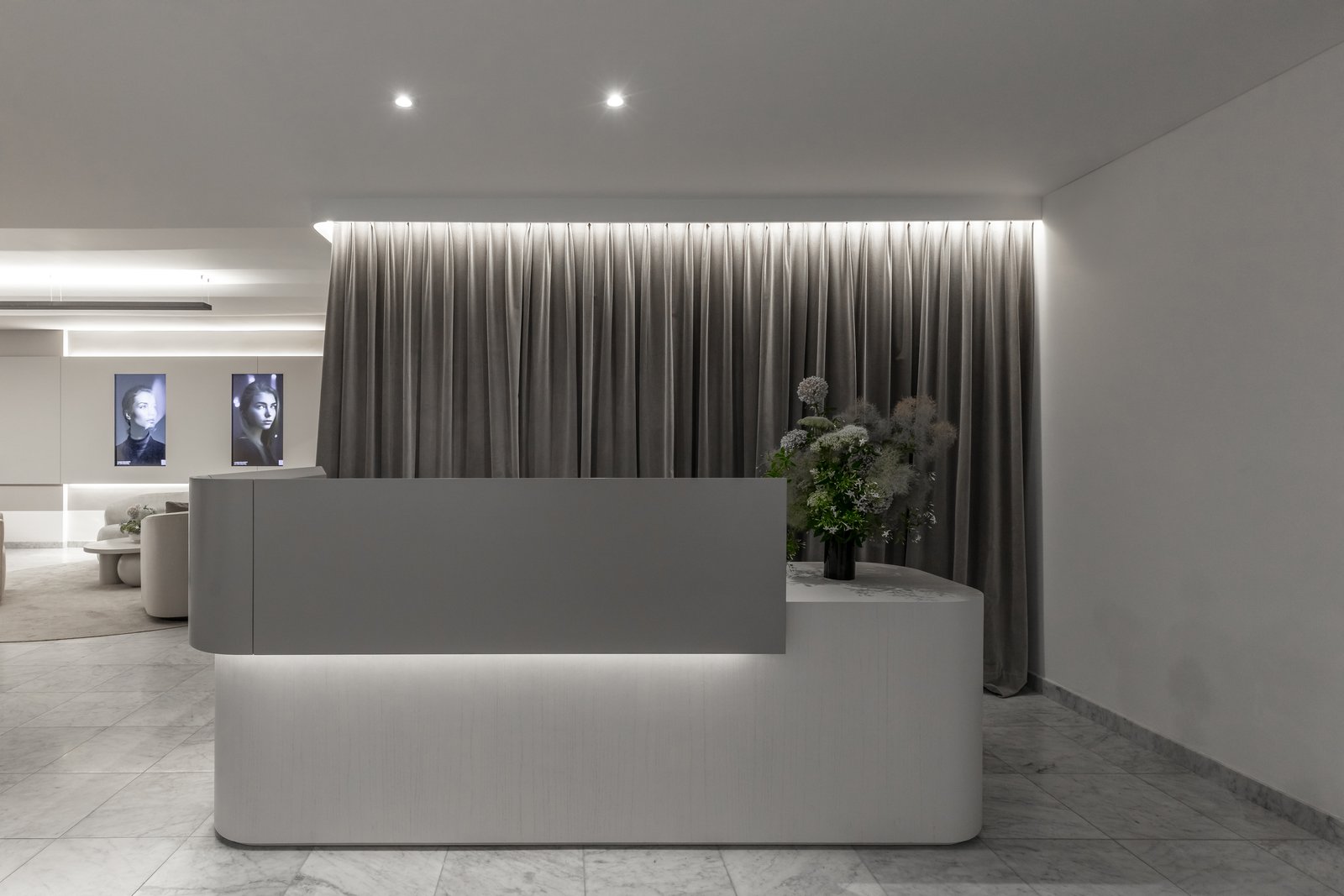 recepción moderna con escritorio blanco y cortinas grises — proyecto Figueroa Alcorta | Rhinoplasty meets art, por Ren Studio, en Palermo Chico