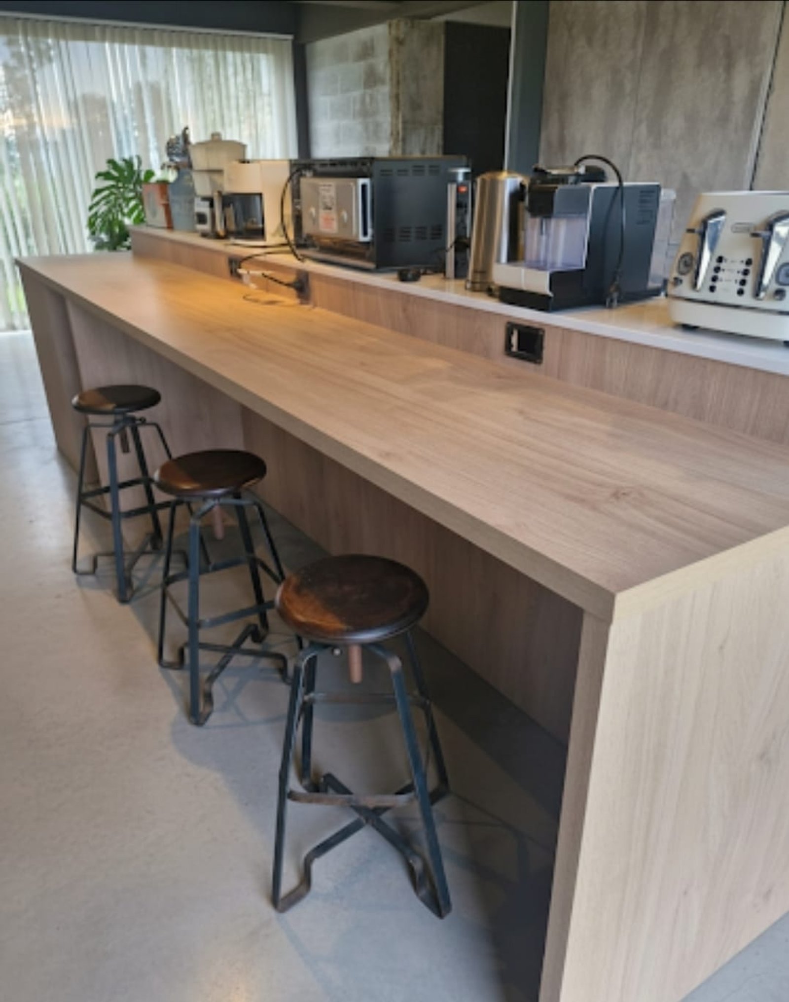 Cocina moderna con barra larga de madera y banquetas industriales — proyecto Proyecto Lujan - Diseño y ejecución integral isla cocina, por MJS INTERIOR DESIGNER, en Luján