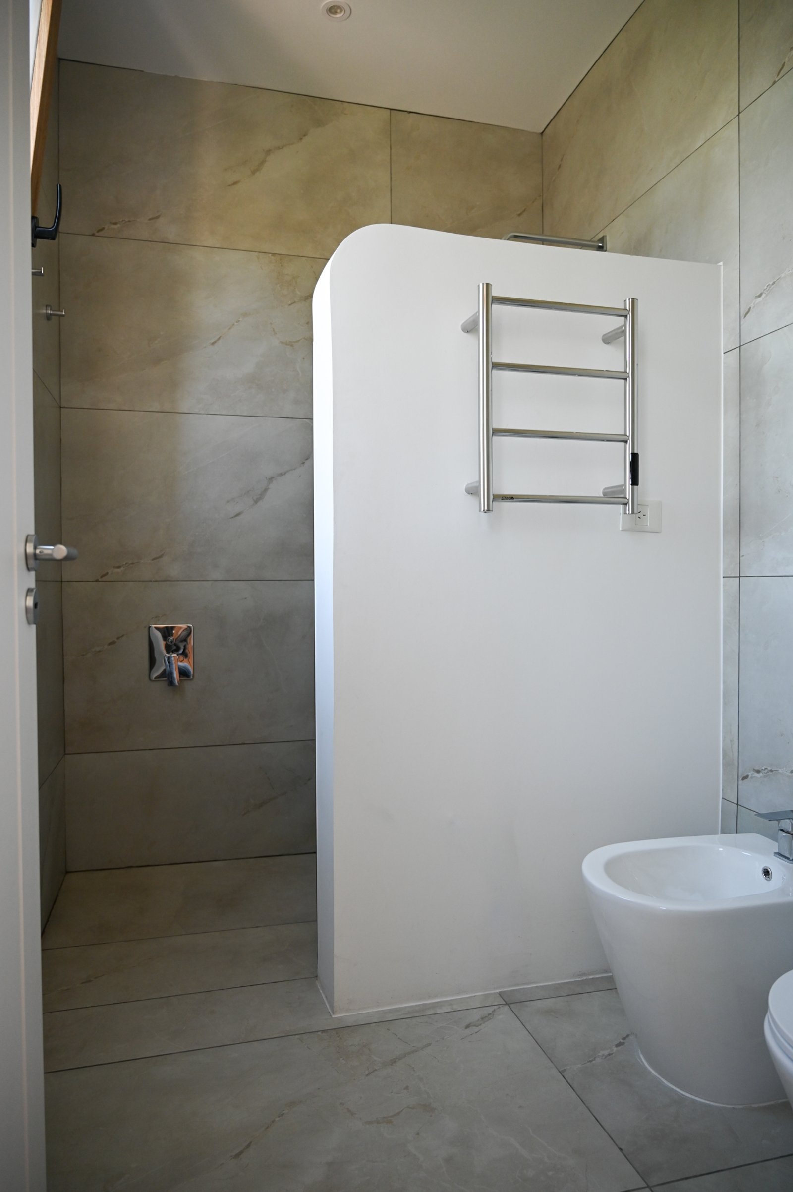 Banheiro moderno com box, bidê e toalheiro aquecido — projeto Baños, por CASA1-TROMEN, em Bella Vista