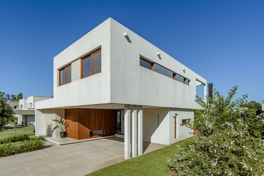 Casa moderna blanca con detalles en madera y grandes ventanales — proyecto Casa Estudio GR, por MUCHTEK, en City Bell