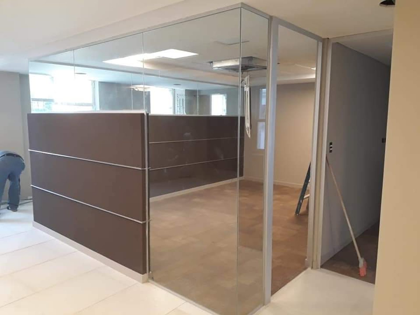 Oficina moderna con divisiones de vidrio y paneles de madera oscura — proyecto Banco Galicia divisores, por Cristalcenter, en Maipú